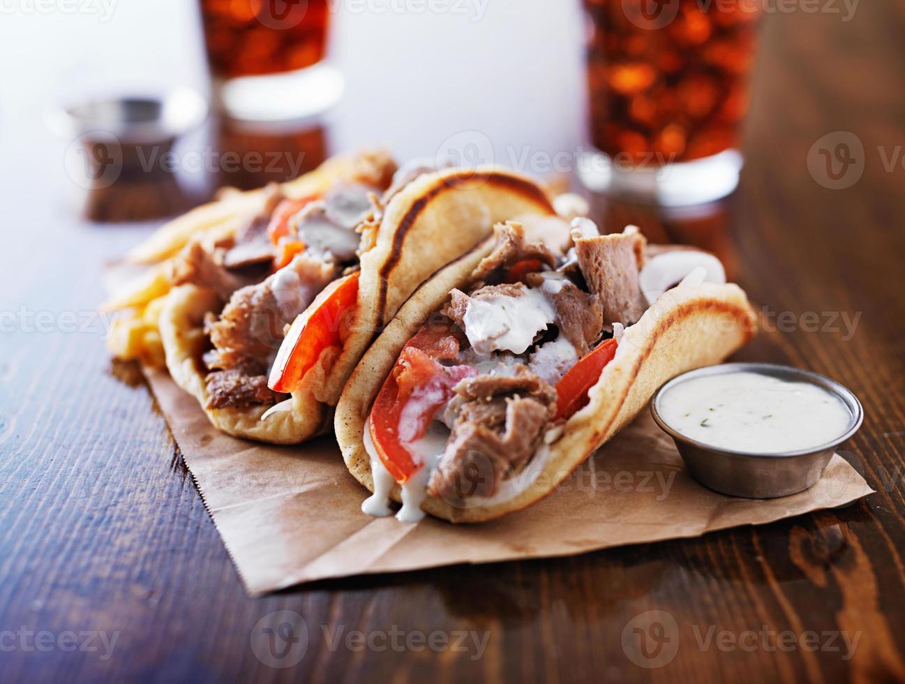 grekiska gyros med tzatzikiisås och pommes frites foto