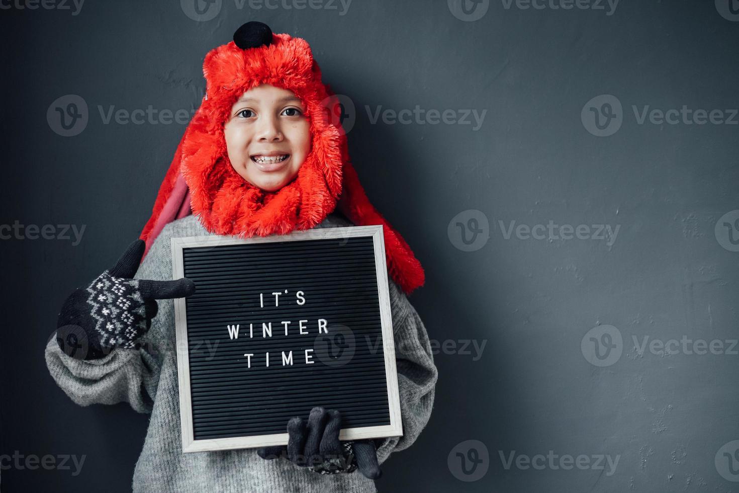 söt pojke med glada uttryck bär vinterkläder välkomnar vintersäsongen foto
