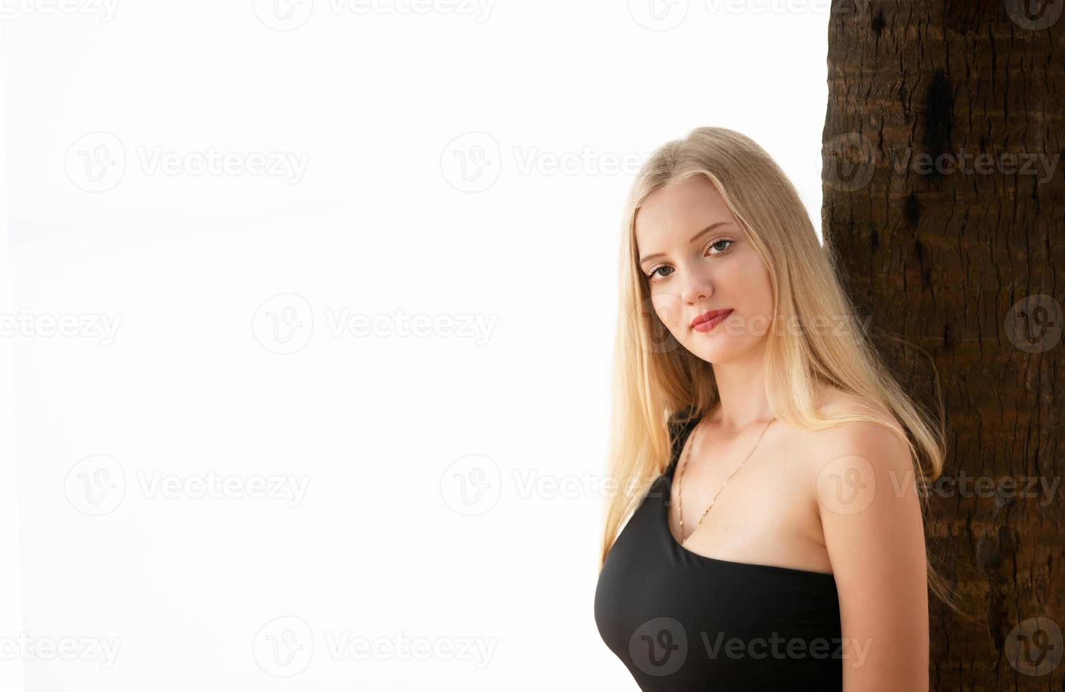 vacker blond kvinna på svart bikini njuta av sommaren på stranden. foto