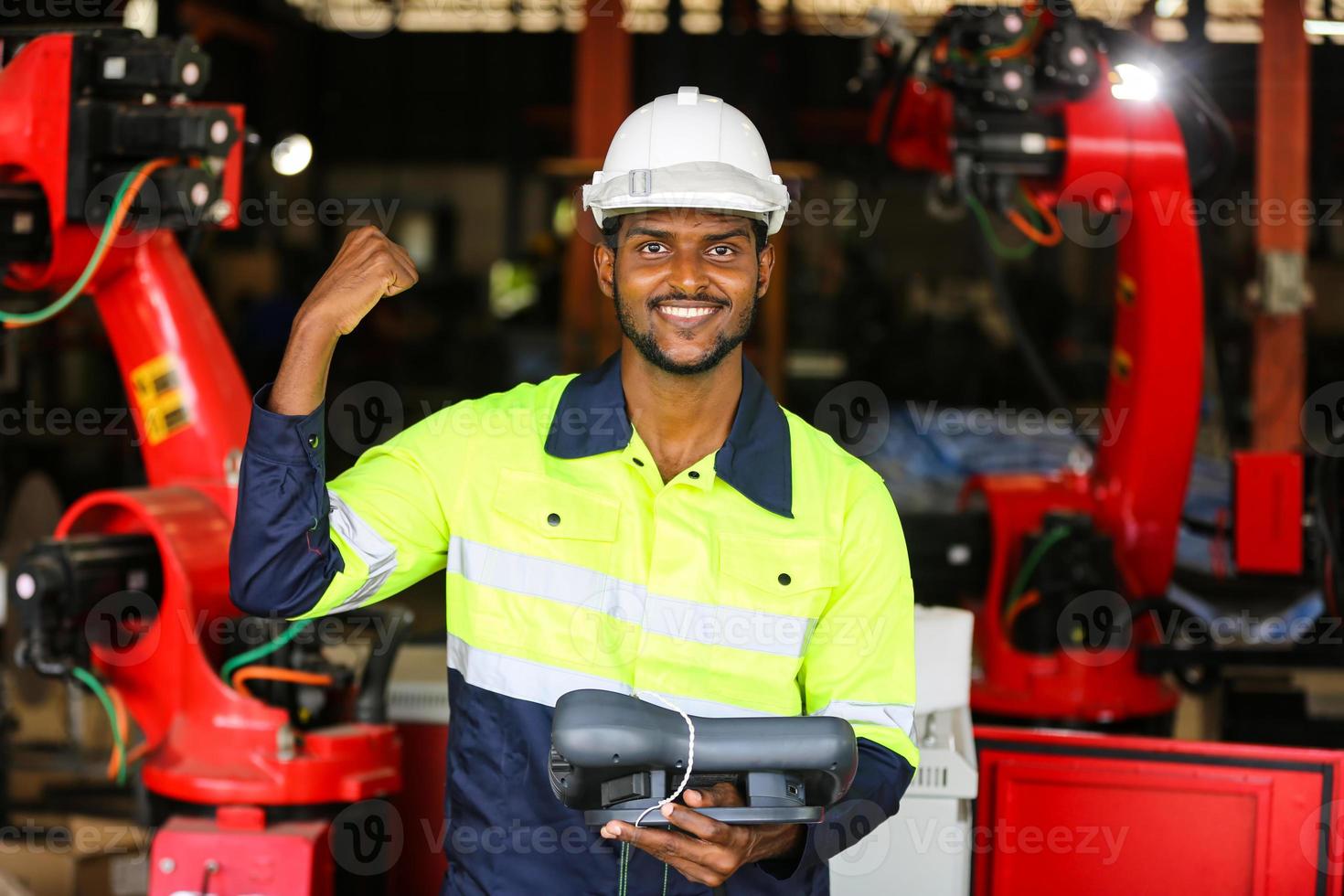 industriell fabriksanställd som arbetar med maskindel, kontrollerar och testar industriell utrustning och robotarmar i en stor fabrik för tillverkning av ledningar och kablar för elektrisk elektronik foto