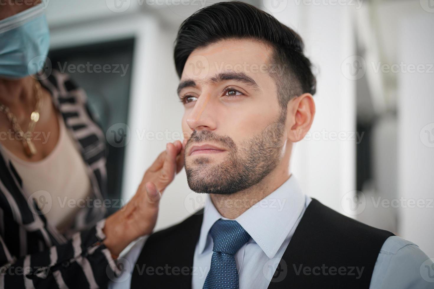 porträtt av stilig man var make up av konstnären på hans ansikte. foto