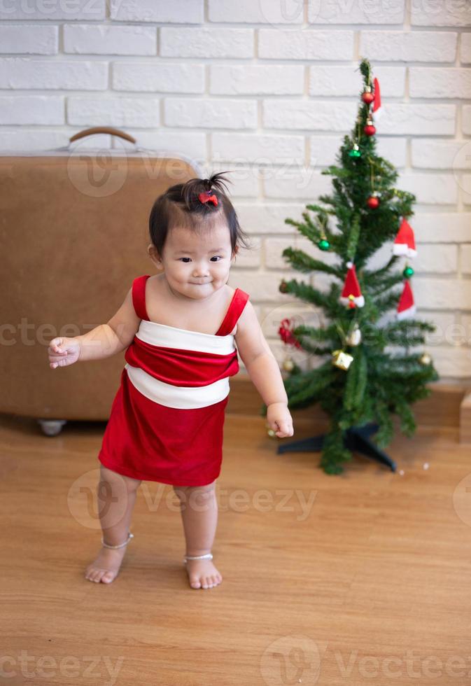liten flicka i röd kostym på juldagen. foto