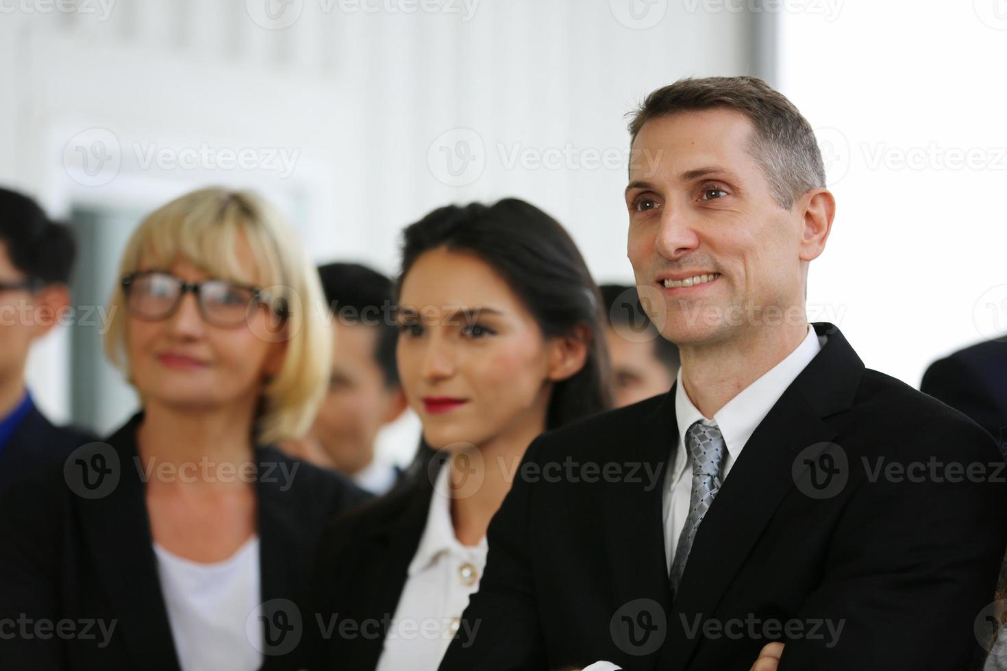 grupp människor som lyssnar på erfaren affärspersonal som hjälper dem att utarbeta en ny företagsstrategi. foto