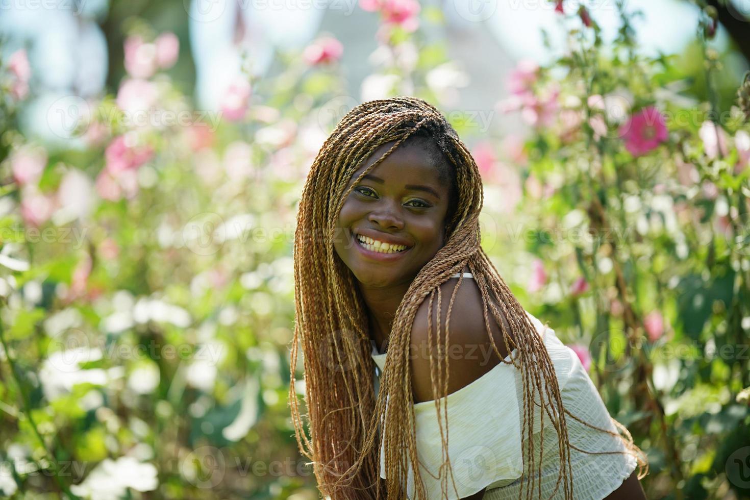 porträtt av ung kvinna med svart hud med afro frisyr pose utomhus. foto