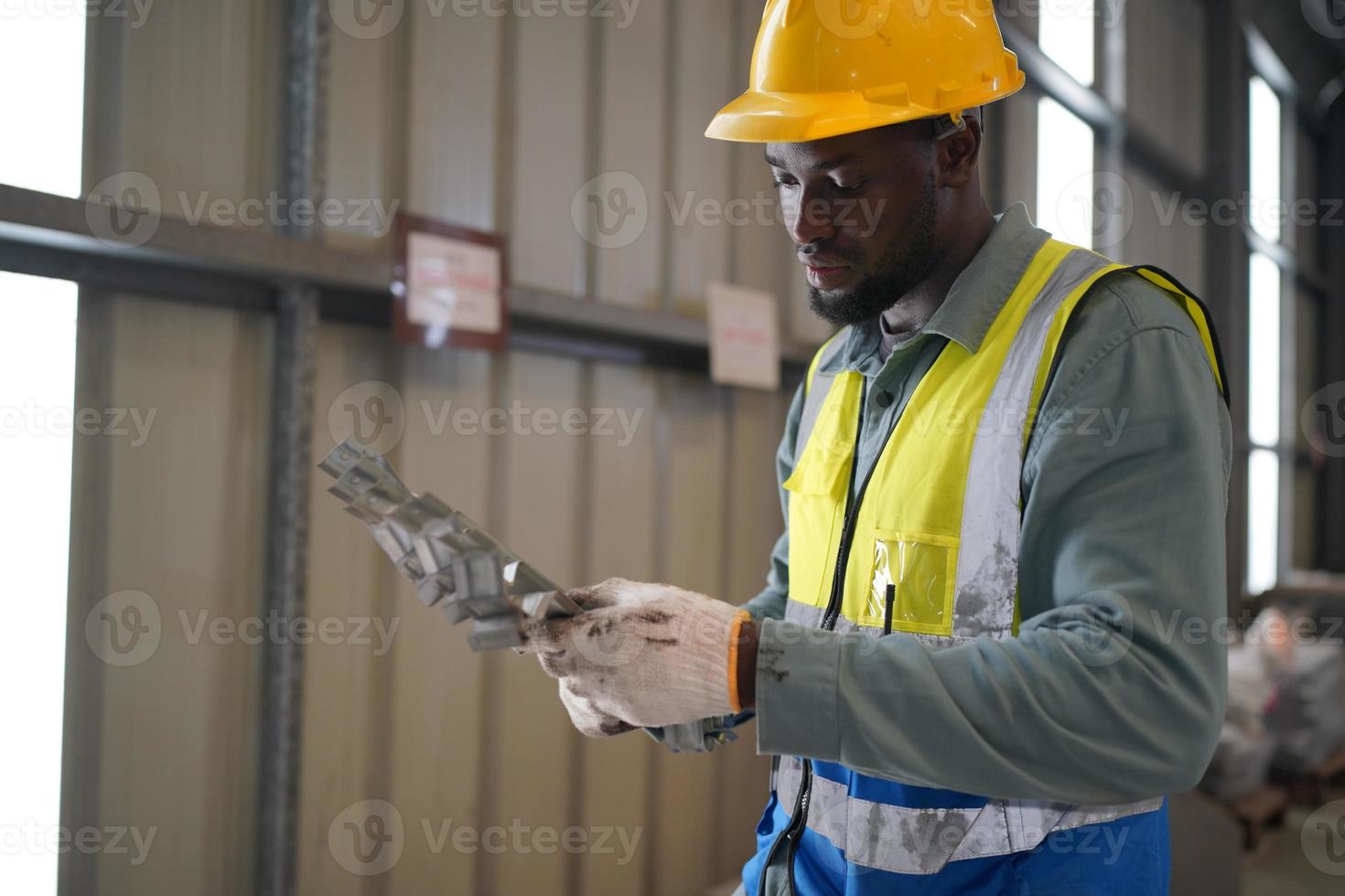 män industriingenjör som bär skyddshjälm när de står i en tung industrifabrik. underhållet av att arbeta på industriella maskiner och kontrollera säkerhetssystemets installation i fabriken. foto