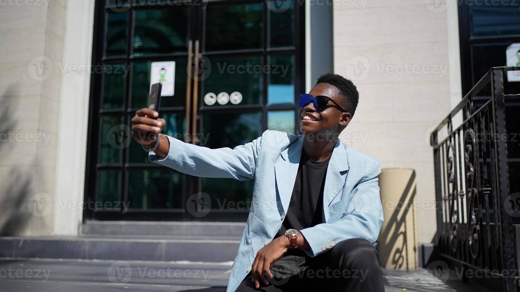 afroamerikansk man har roligt att gå i stadens centrum - glad ung kille som njuter av tiden en solnedgång utomhus - tusenårig generation livsstil och positiva människor attitydkoncept foto