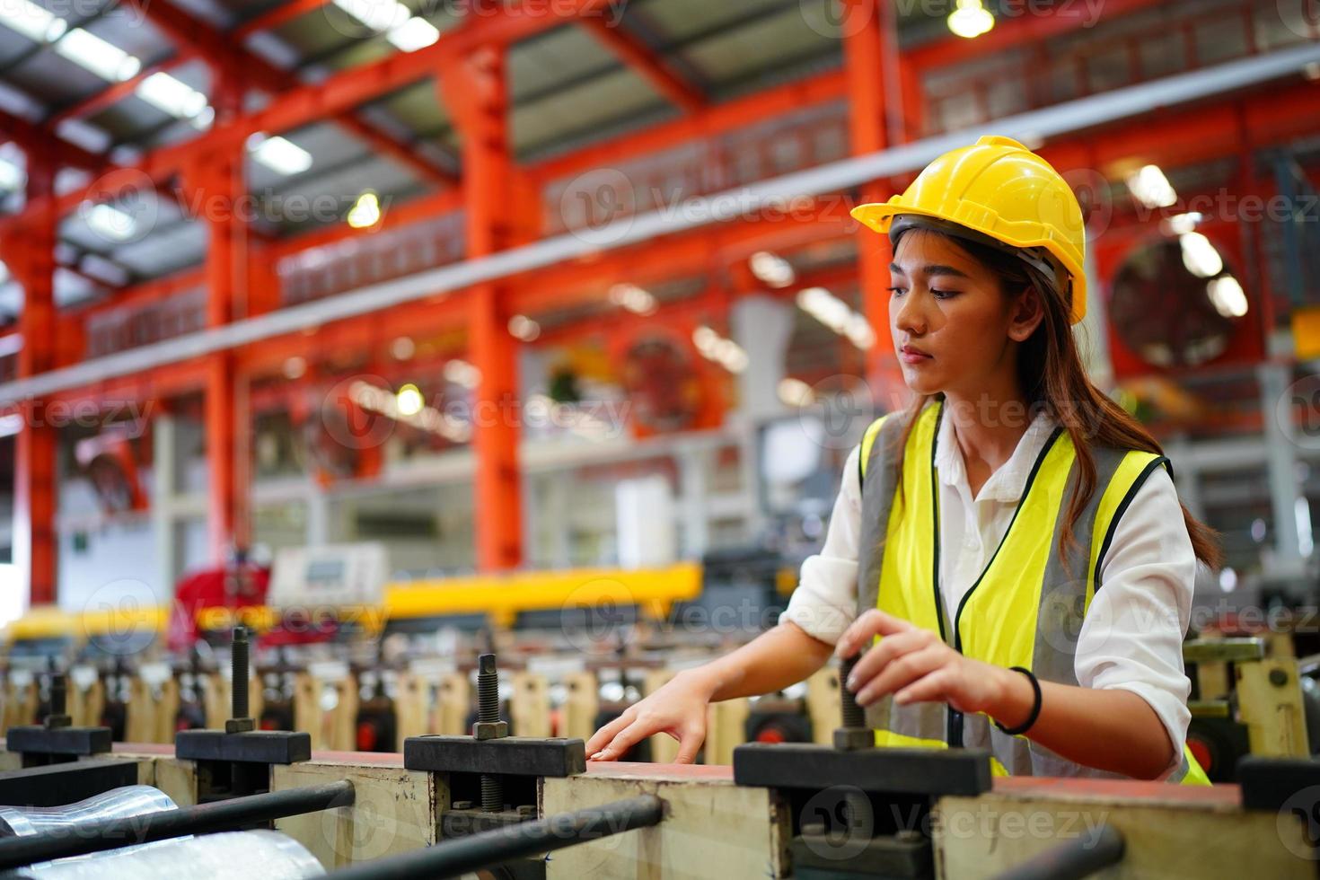 kvinnlig arbetare förman eller arbetare arbete på fabriksplatsen kontrollera maskin eller produkter på plats. ingenjör eller tekniker som kontrollerar material eller maskin på anläggningen. industri och fabrik. foto