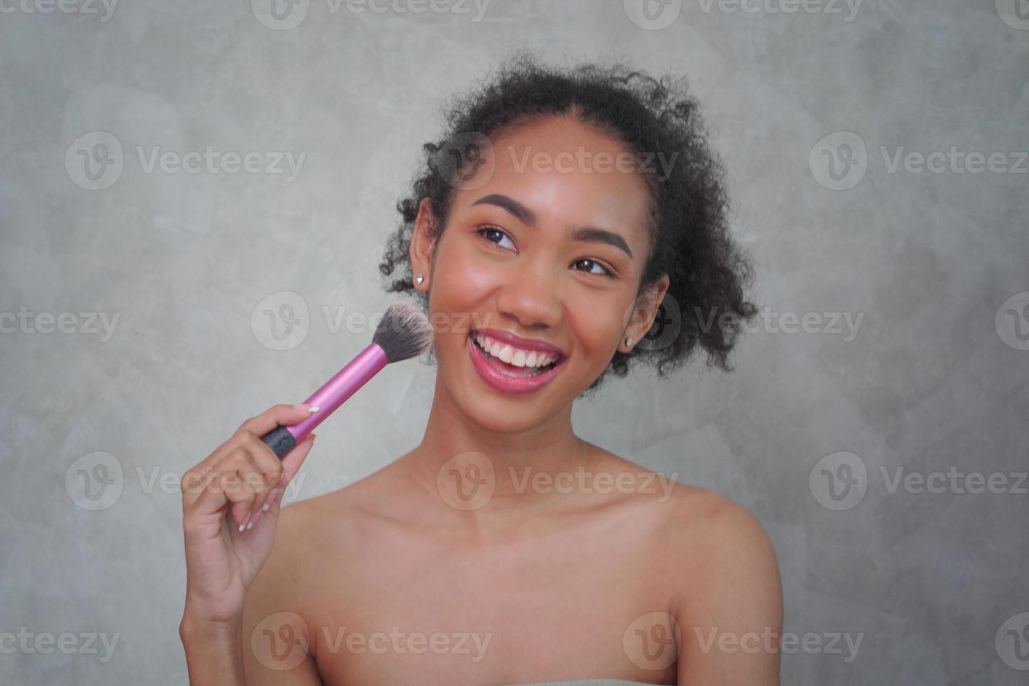 porträtt av lugn nöjd afroamerikansk kvinna med buskig lockig frisyr, foto