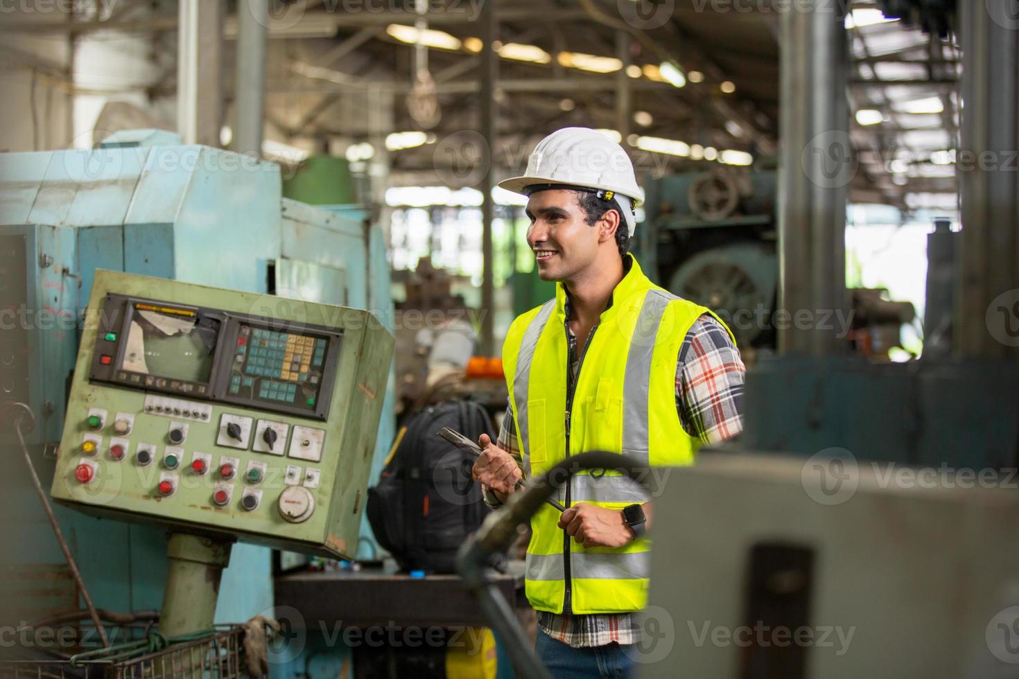 arbetararbete på fabriksplatsen kontrollera maskin i produktlinje eller produkter på plats. ingenjör eller tekniker som kontrollerar material eller maskin på anläggningen. industri och fabrik. foto