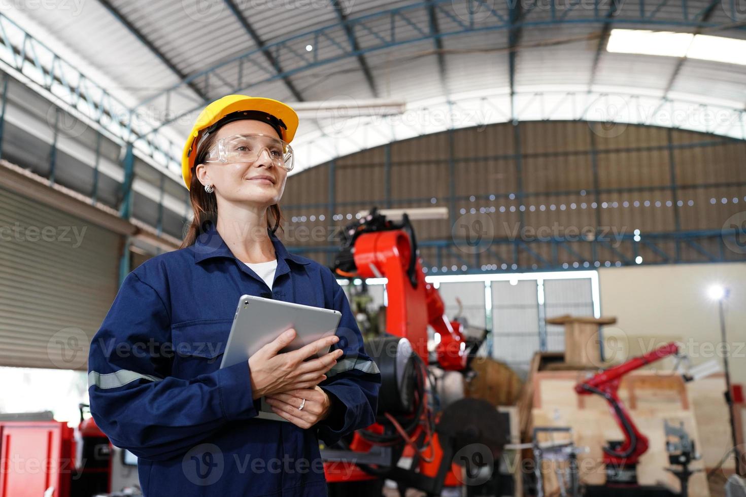 professionell ung industriell fabrikskvinna anställd som arbetar med maskindel, kontrollerar och testar industriell utrustning och robotarmar i stor elektrisk elektronikledning och tillverkningsanläggning foto