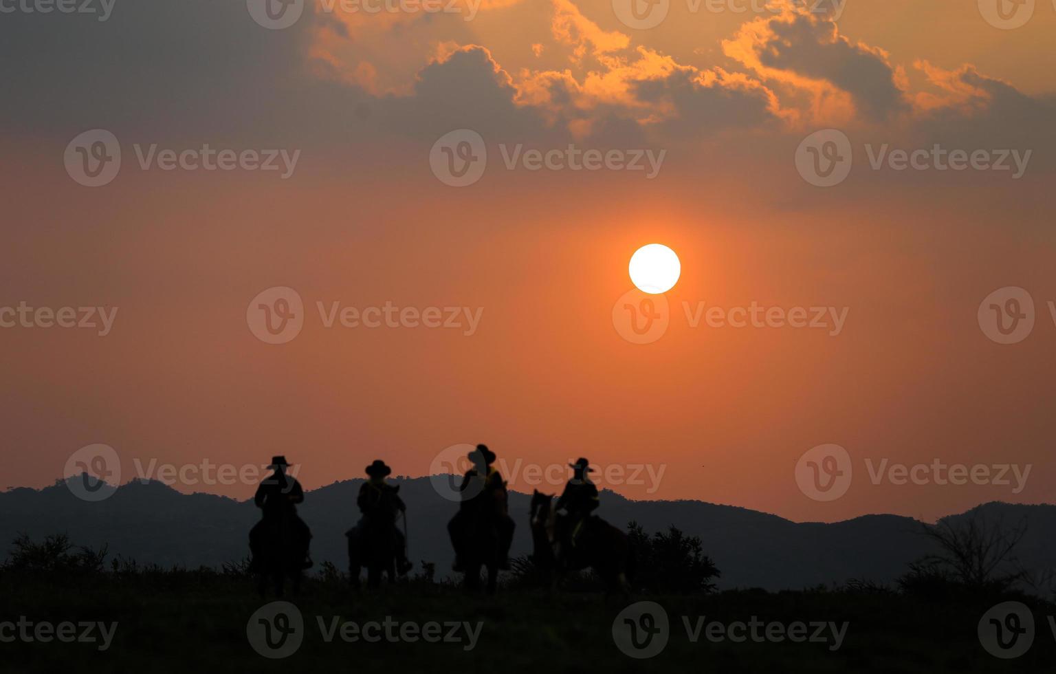 siluett cowboy på hästryggen mot en vacker solnedgång, cowboy och häst vid första ljuset, berg, flod och livsstil med naturligt ljus bakgrund foto