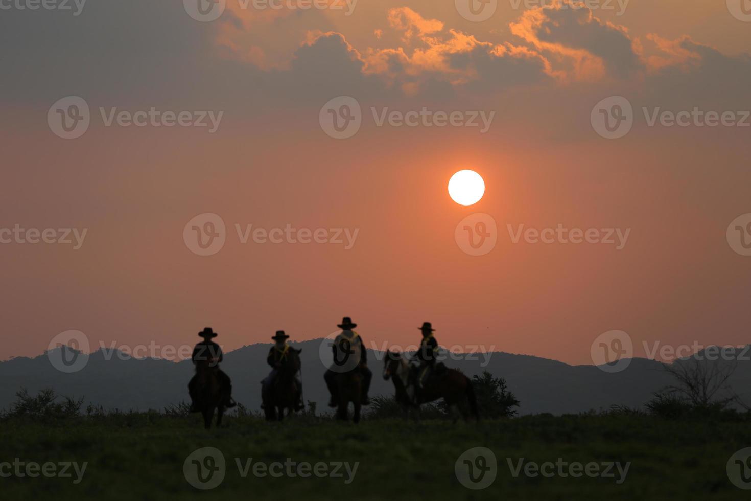 siluett cowboy på hästryggen mot en vacker solnedgång, cowboy och häst vid första ljuset, berg, flod och livsstil med naturligt ljus bakgrund foto