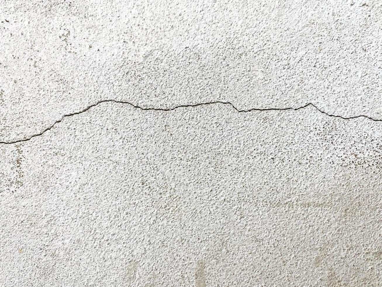 spricka betongvägg textur bakgrund. närbild vit spricka vägg bakgrund i byggnaden foto