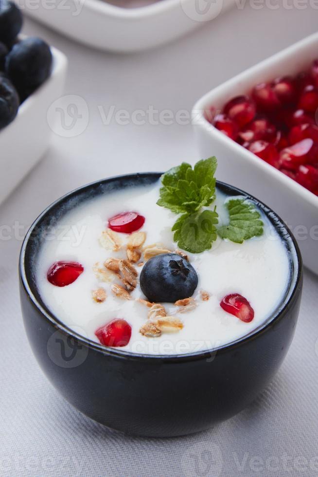 yoghurt med spannmål, blåbär och granatäpple foto