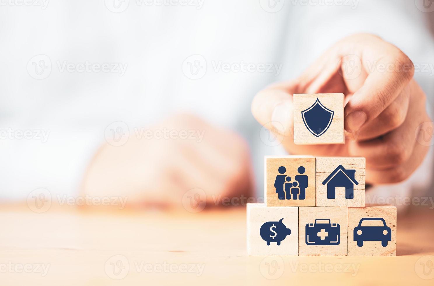 affärsman sätta trä kub block stapling med försäkring och garanti ikon inklusive familj hälsa fastigheter bil och finansiella för riskhantering koncept. foto