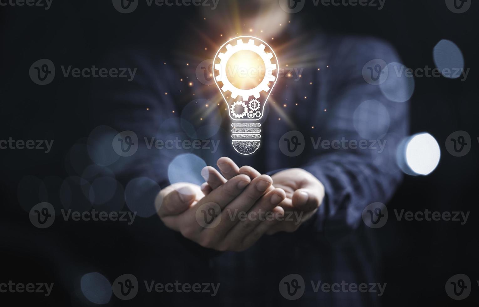 affärsman som håller glödande glödlampa med mekanisk utrustning och orange ljusstråle för inspiration kreativt tänkande och framtida innovationsteknologikoncept. foto