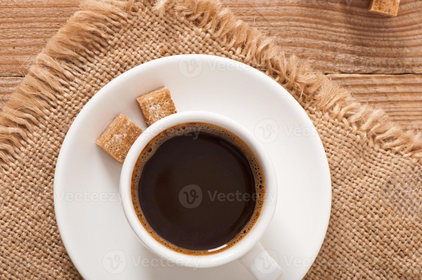 närbild av en kopp kaffe, farinsocker och kaffebönor foto