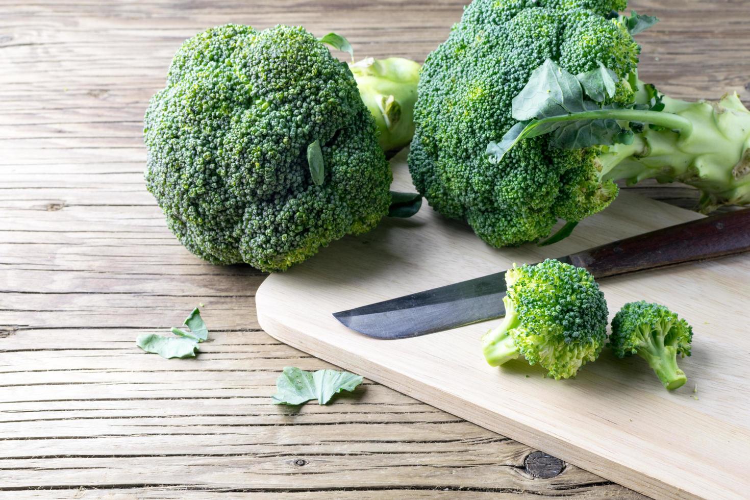 färsk broccoli på en skärbräda och kniv foto