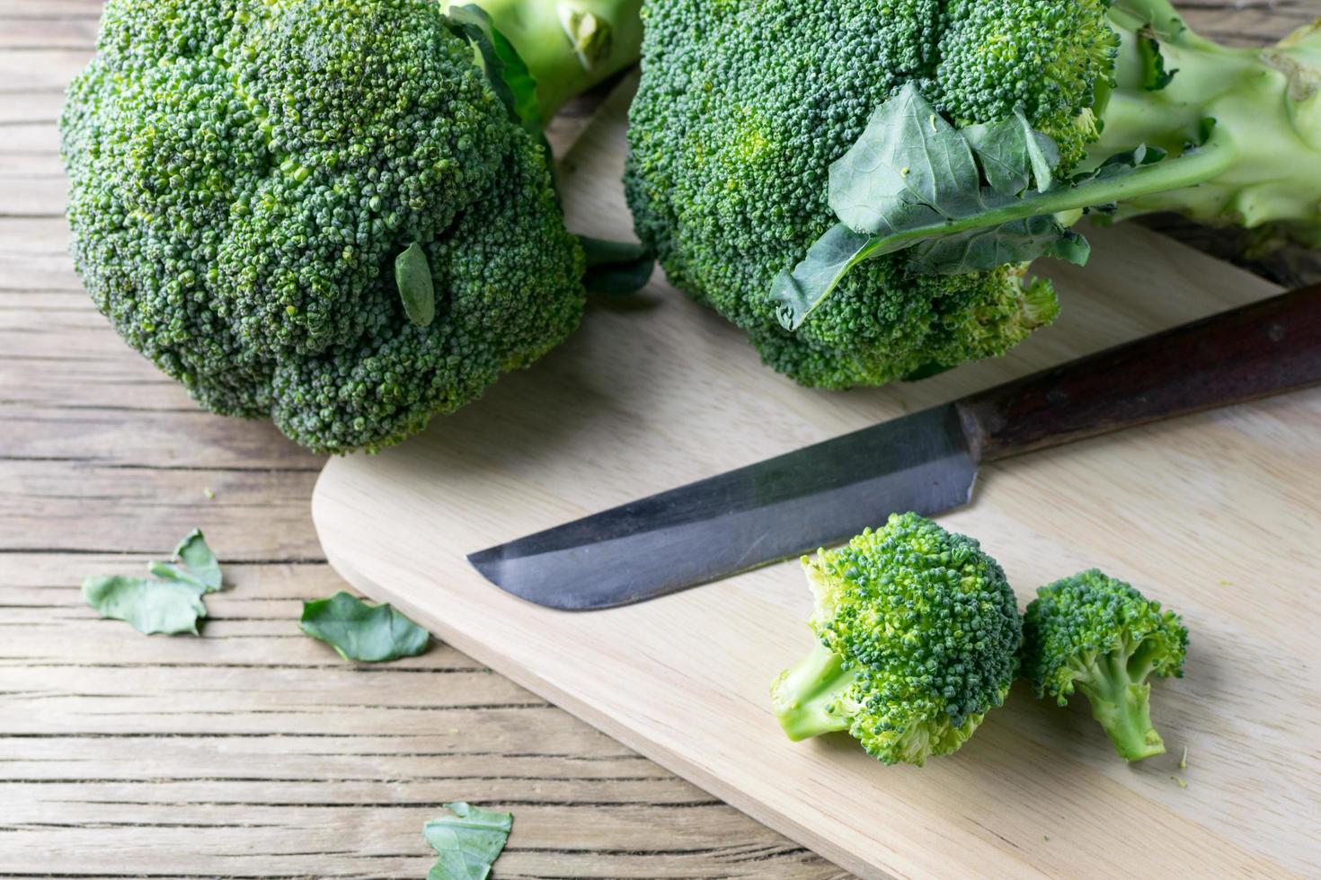 färsk broccoli på en skärbräda och kniv foto