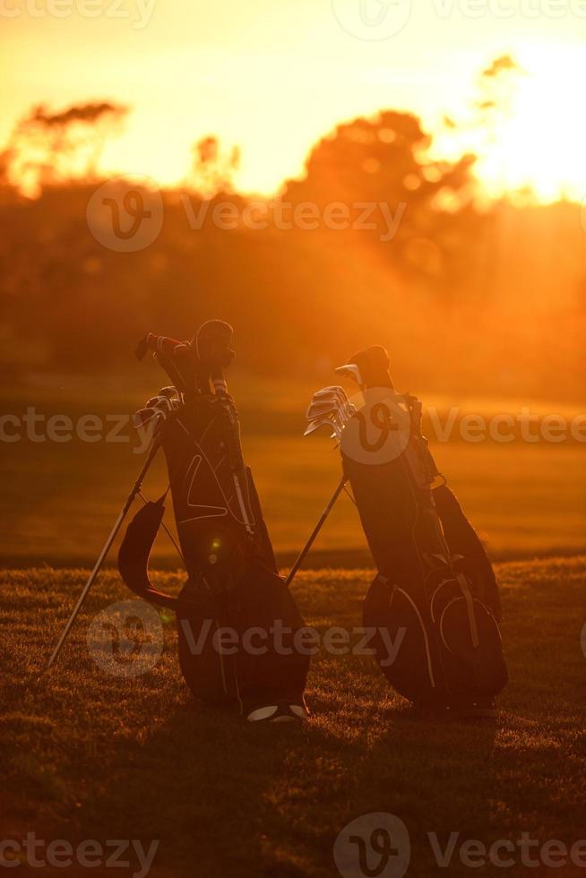 golfväskor vid solnedgången foto