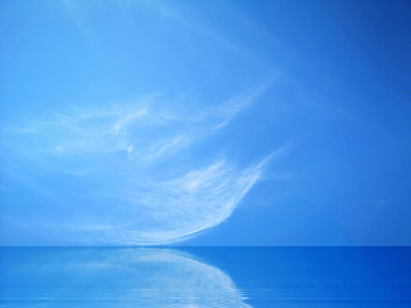 blå himmel och vita moln reflekteras på vattenytan. foto