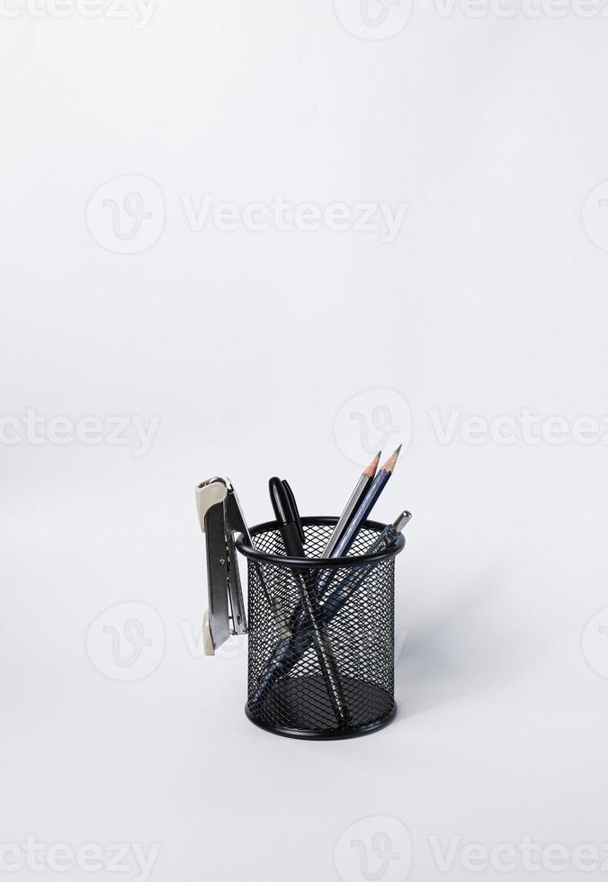 en liten svart korg av rundstål. kan användas för att lagra kontorsmateriel, inklusive pennor, pennor, häftapparat, och fortfarande ha utrymme för att lägga fler saker. i den vita bakgrunden finns kopieringsutrymme. foto