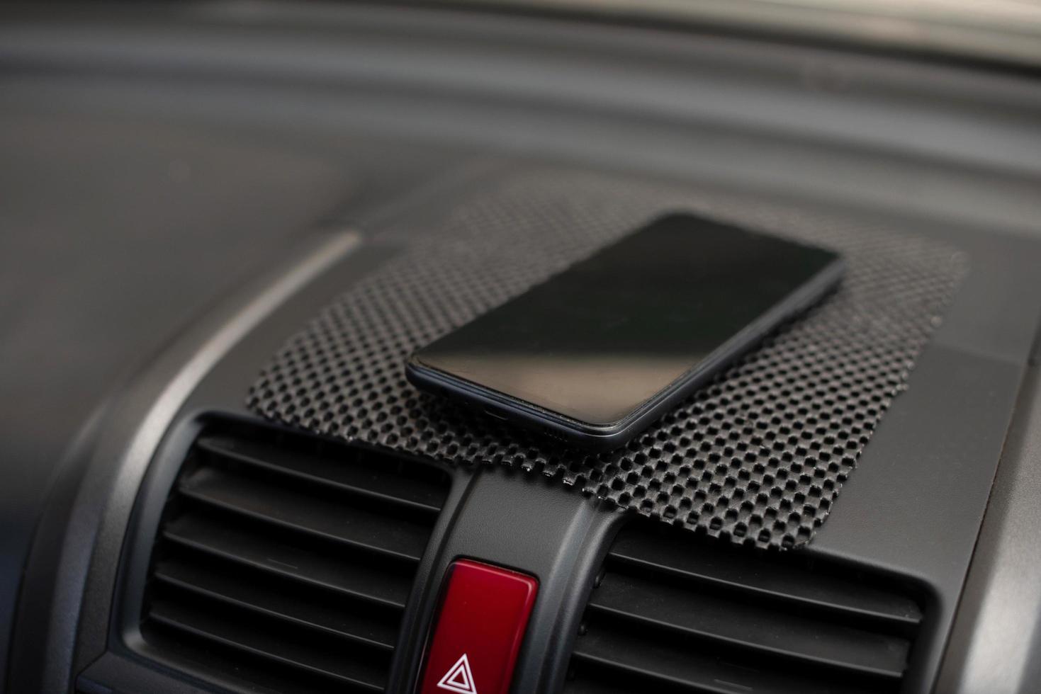 mobiltelefon placerad på bilens instrumentbräda foto