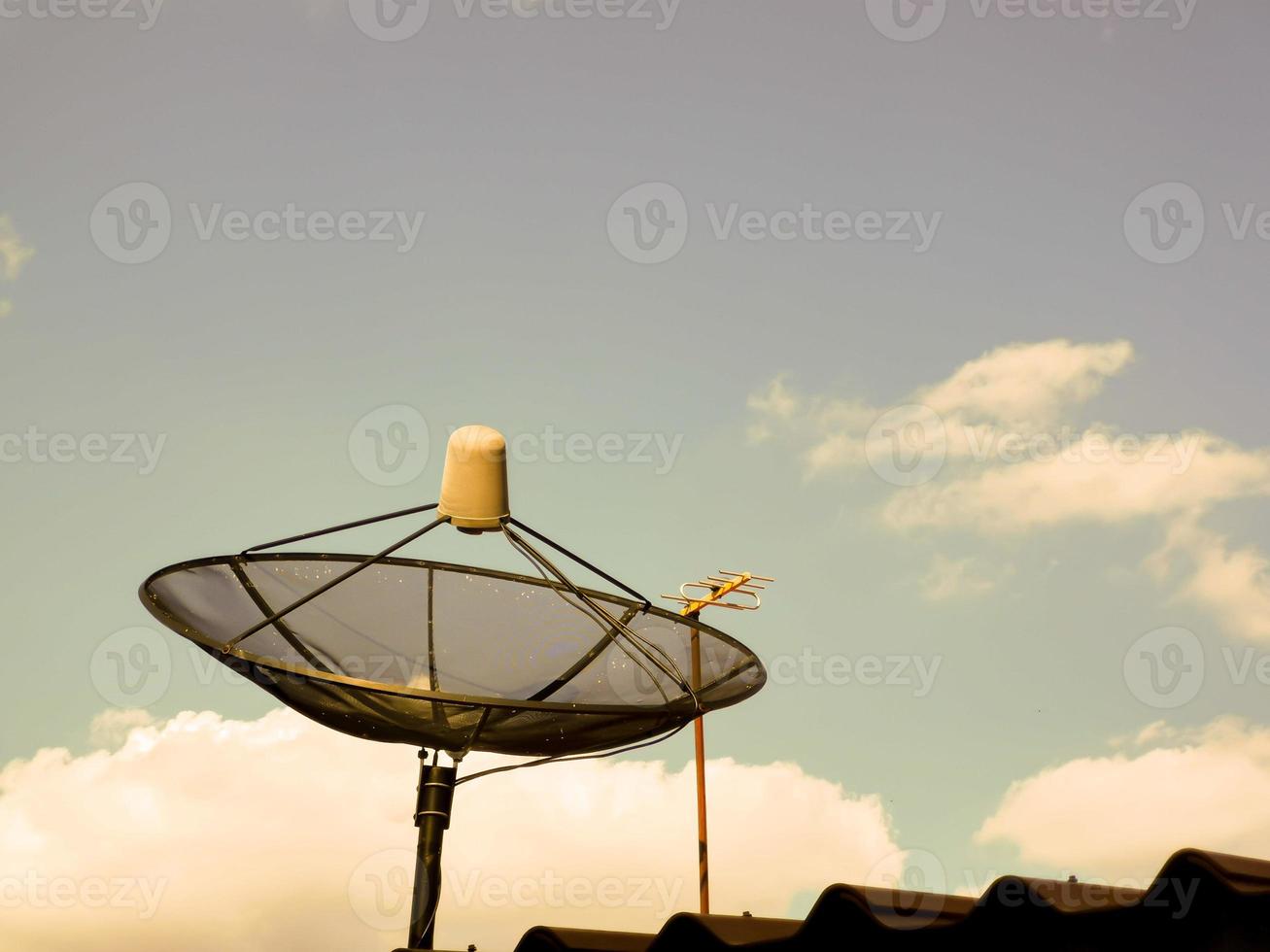 TV parabol på taket av huset på kvällen foto