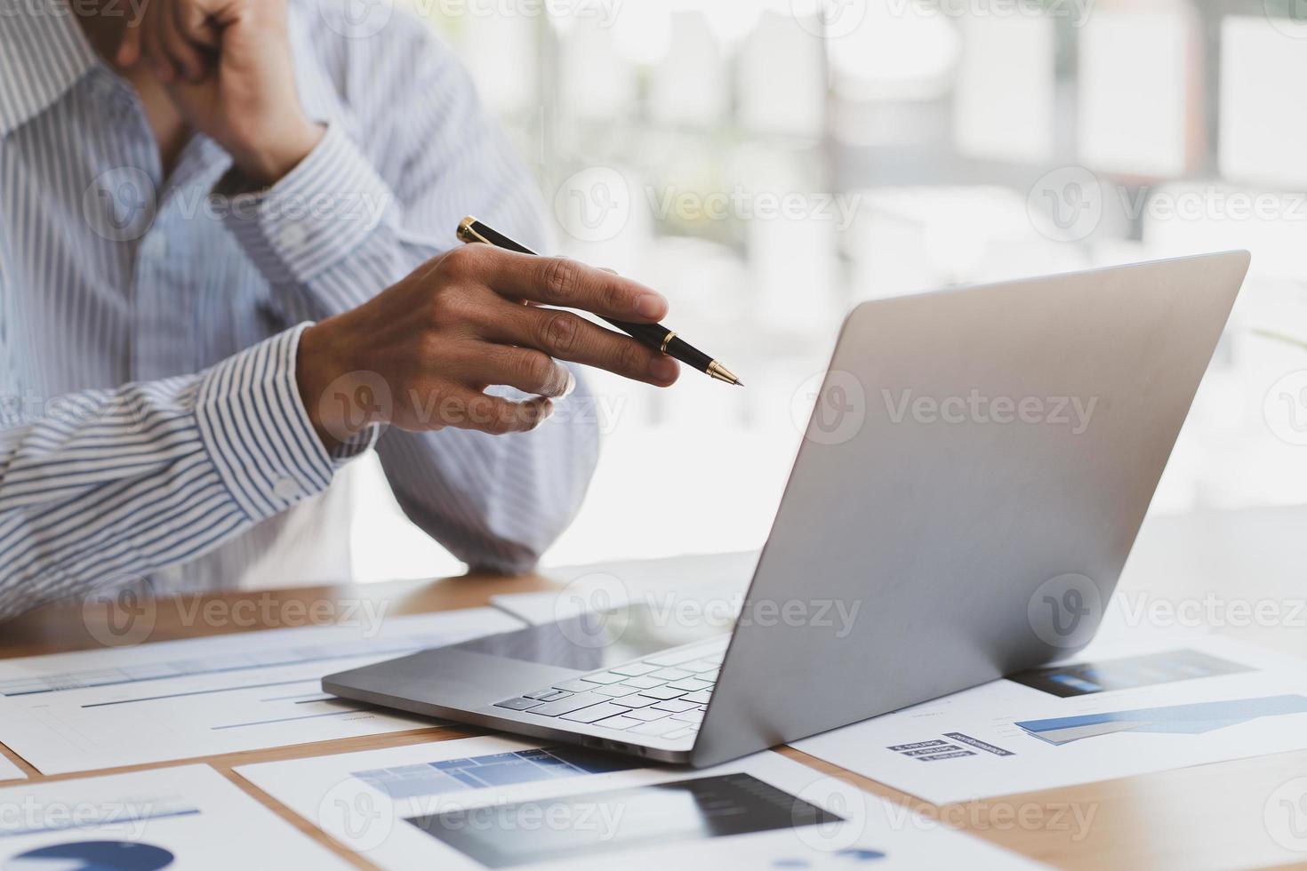 chefen använder en bärbar dator medan han analyserar företagets bokslut på skärmen. foto