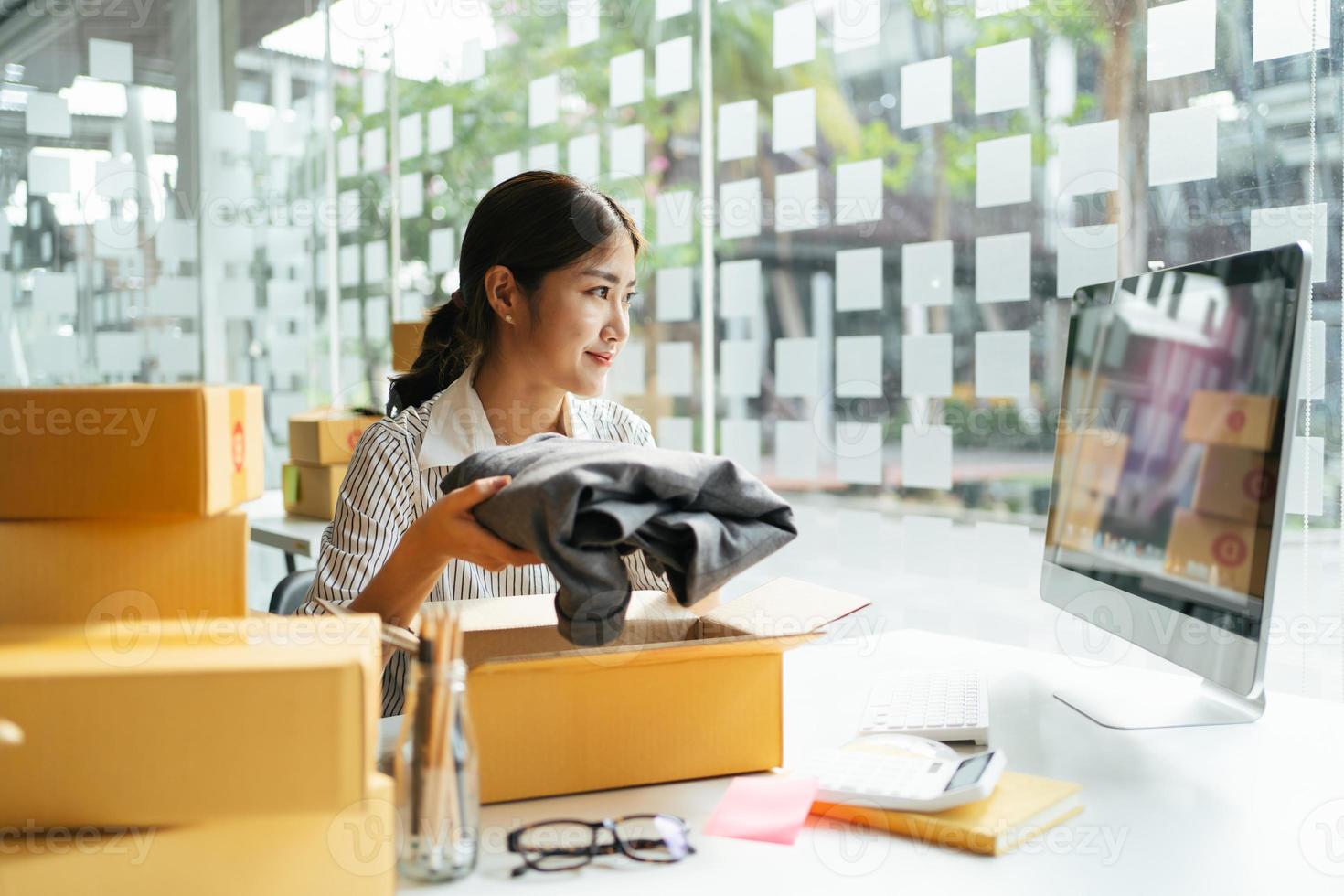 porträtt ung attraktiv asien kvinnlig ägare uppstartsföretag arbeta nöjd med låda hemma förbereda paketleverans i SM-försörjningskedjan, upphandling, online-koncept för omnikanalhandel. foto