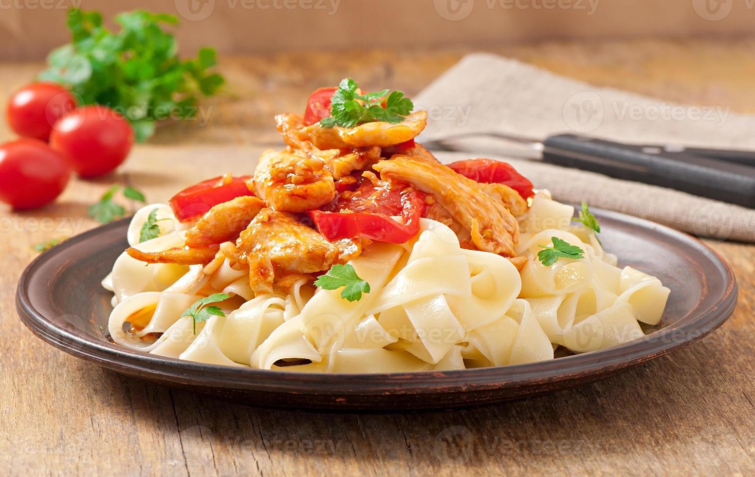 tagliatelle pasta med tomater och kyckling foto