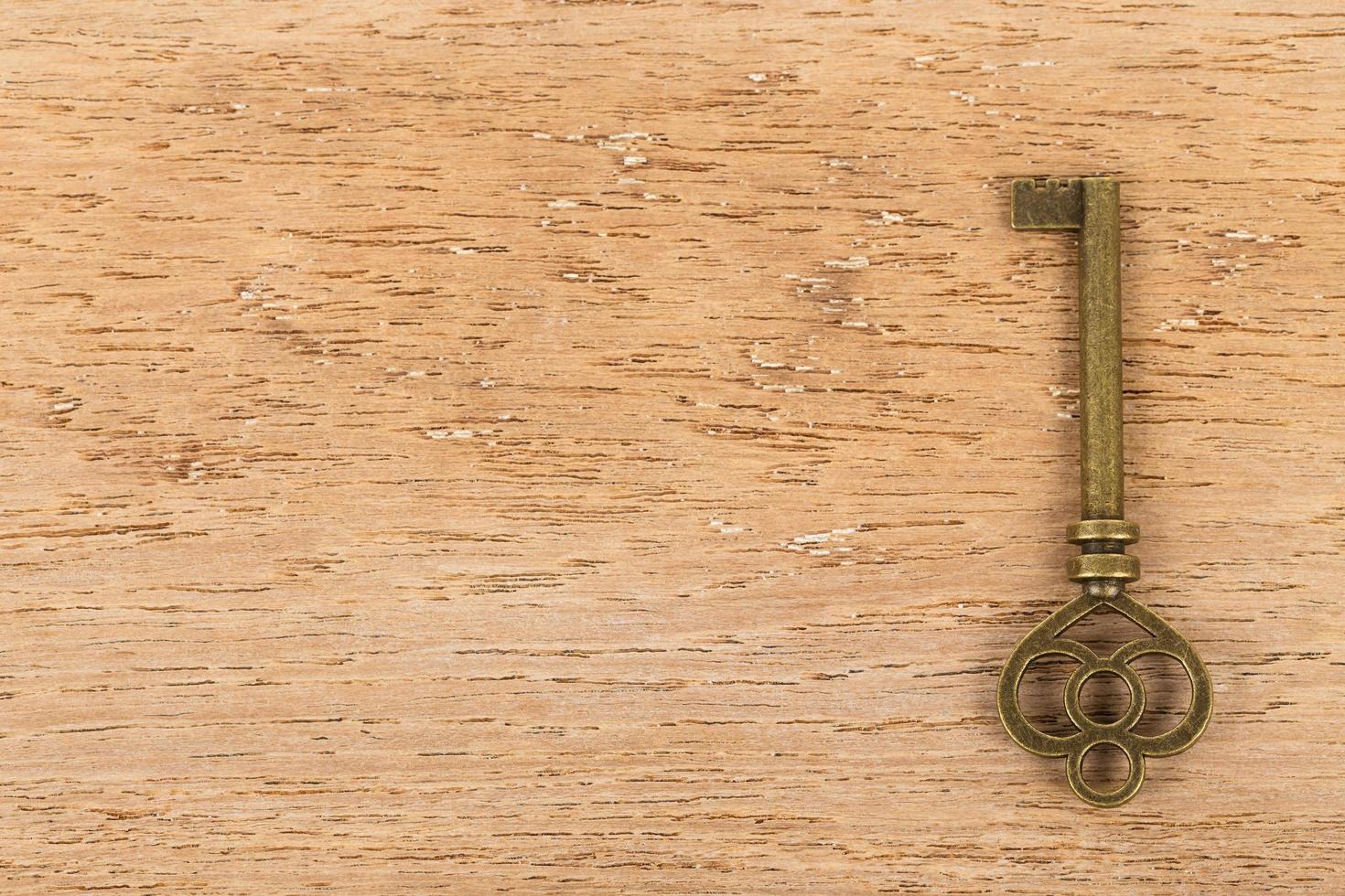 antik nyckel på trä bakgrund foto