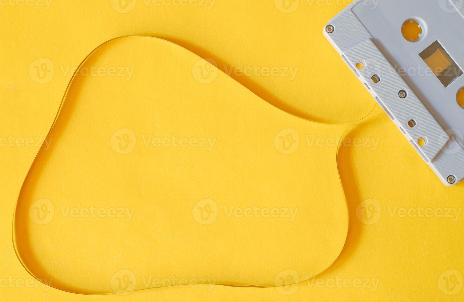 ovanifrån fotografi av gammal plastkassett med kopieringsutrymme magnetband på isolerad gul bakgrund. foto