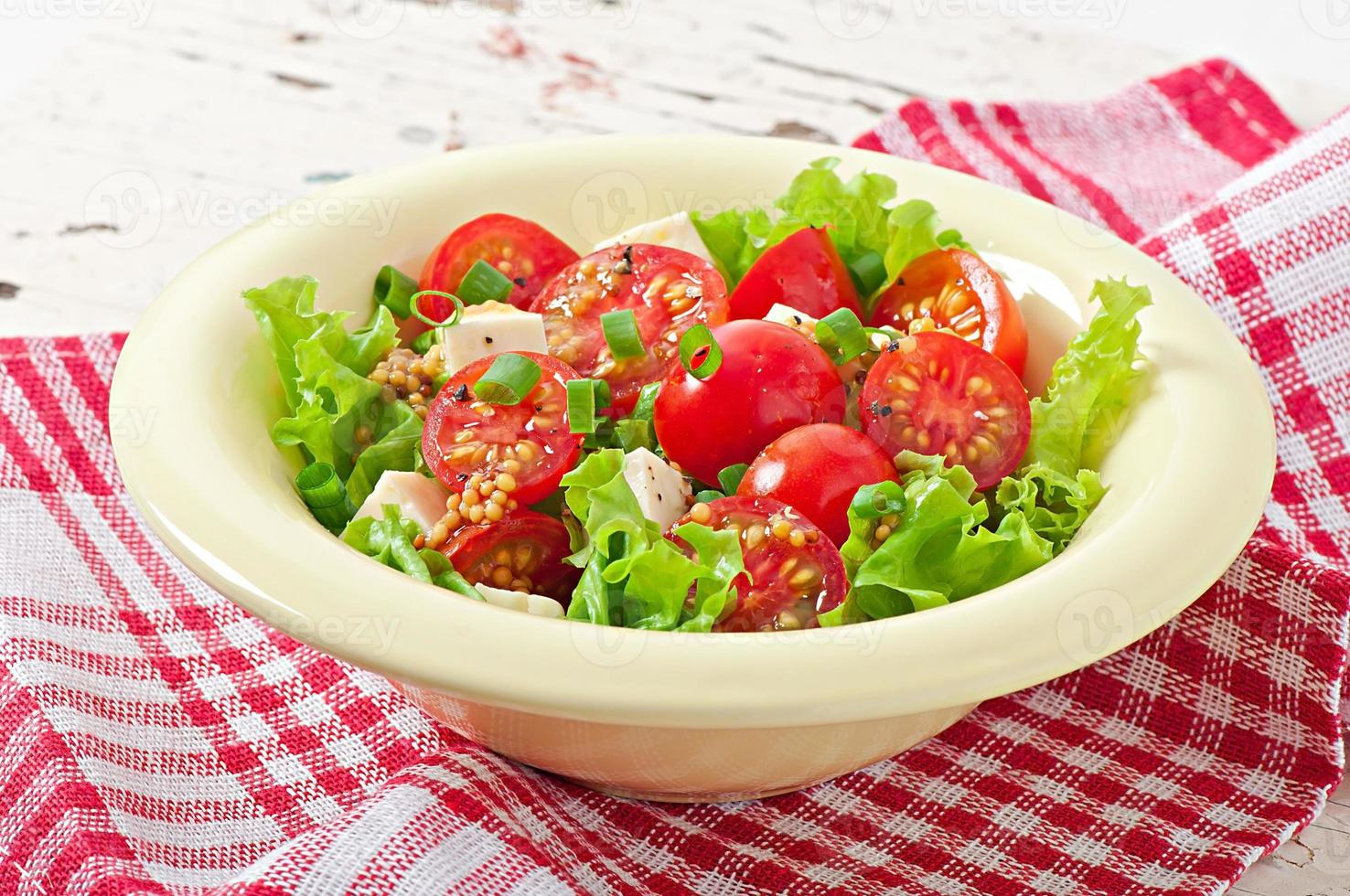 tomatsallad med sallad, ost och senap och vitlökdressing foto