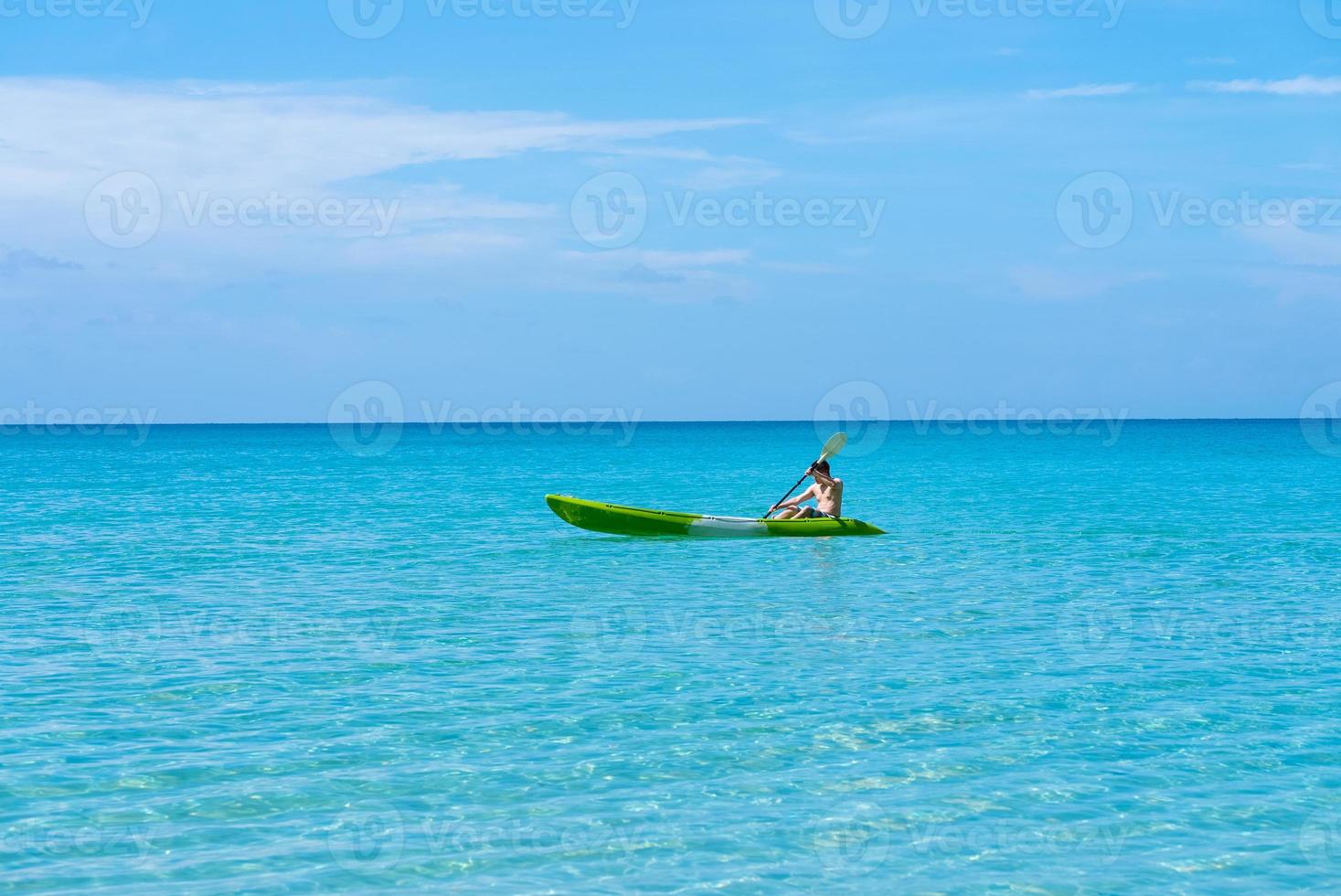 bakifrån av vuxen man paddla kajak i blått hav på sommaren foto