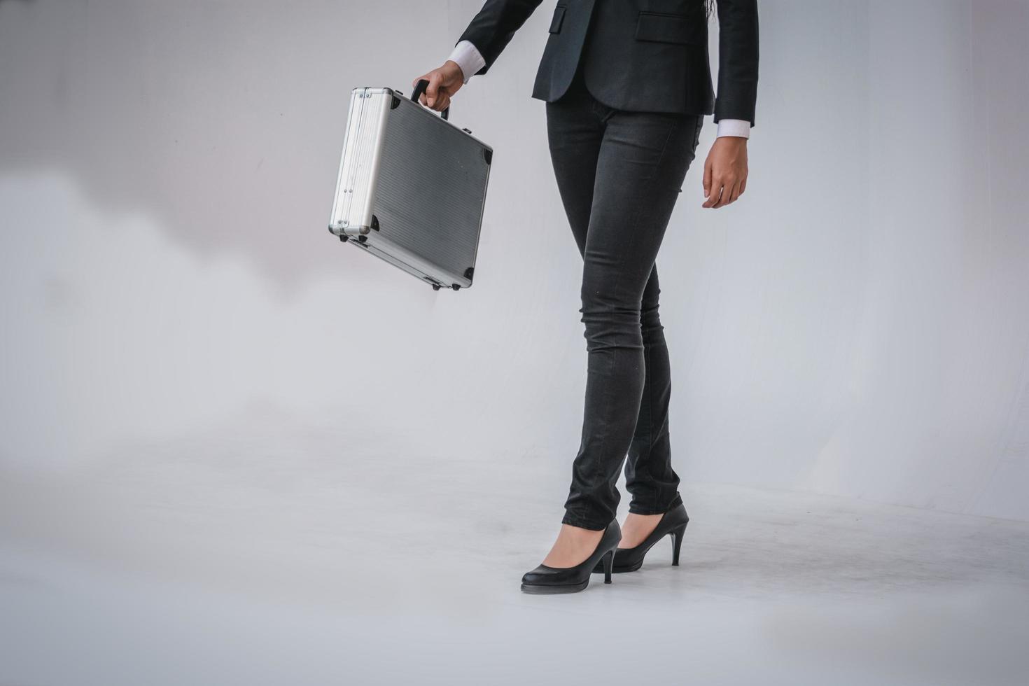 smart kvinna i svart kostym håller portfölj foto