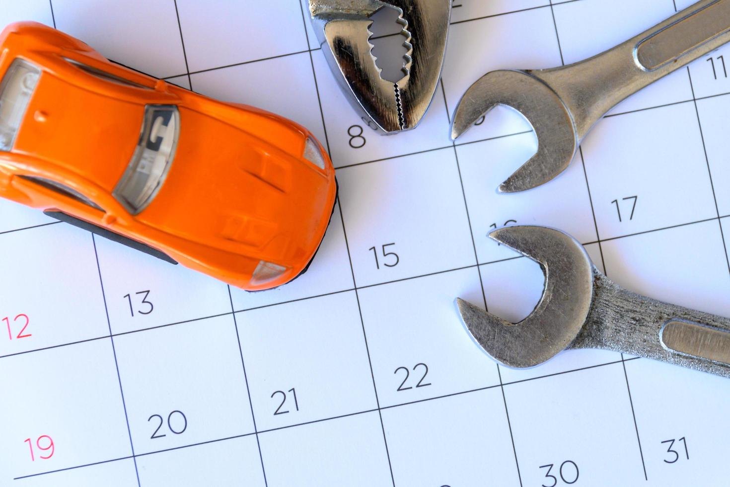 skiftnyckel och bil på kalendern med siffror. reparation koncept foto