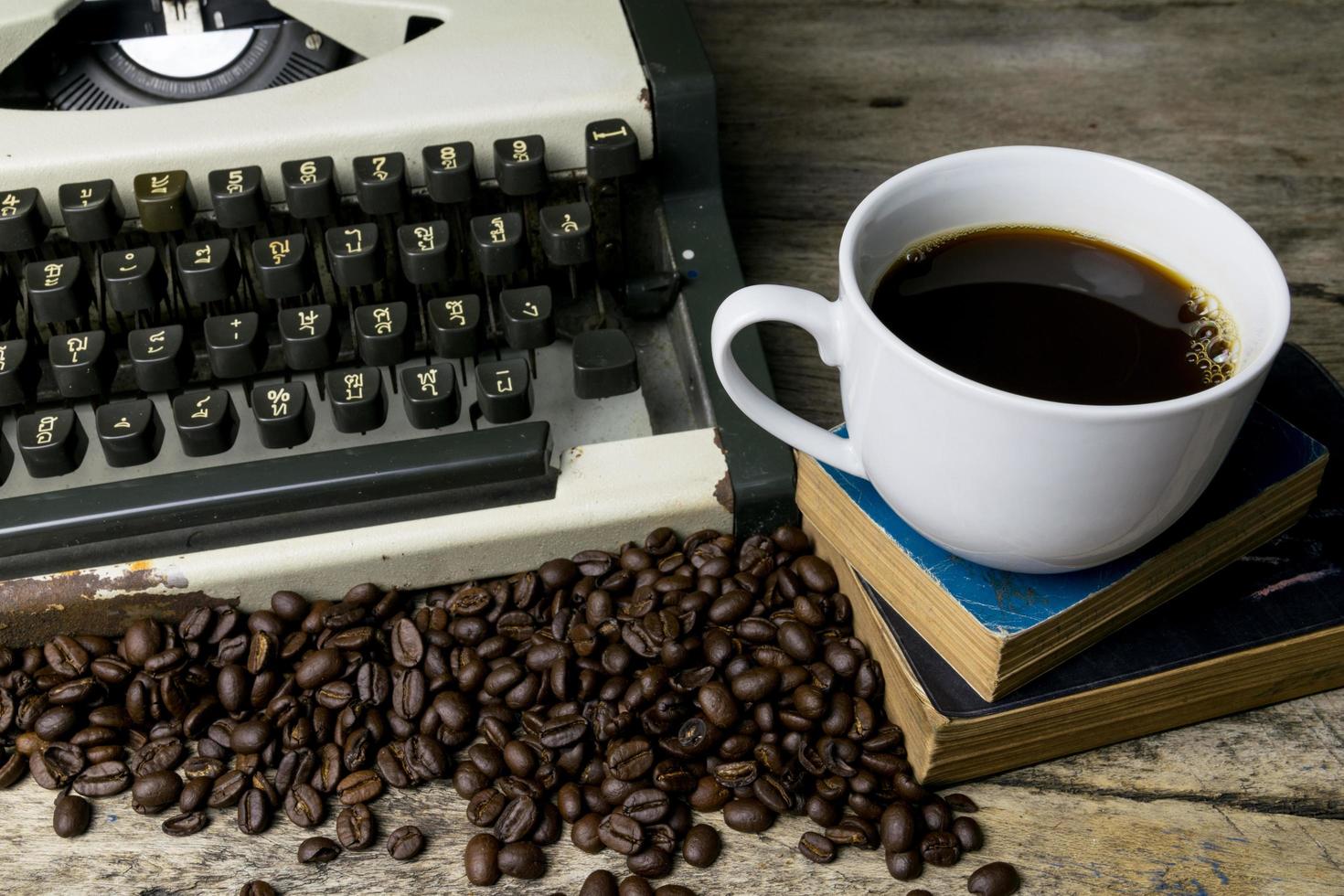 skrivmaskin och kaffe på trä bakgrund foto