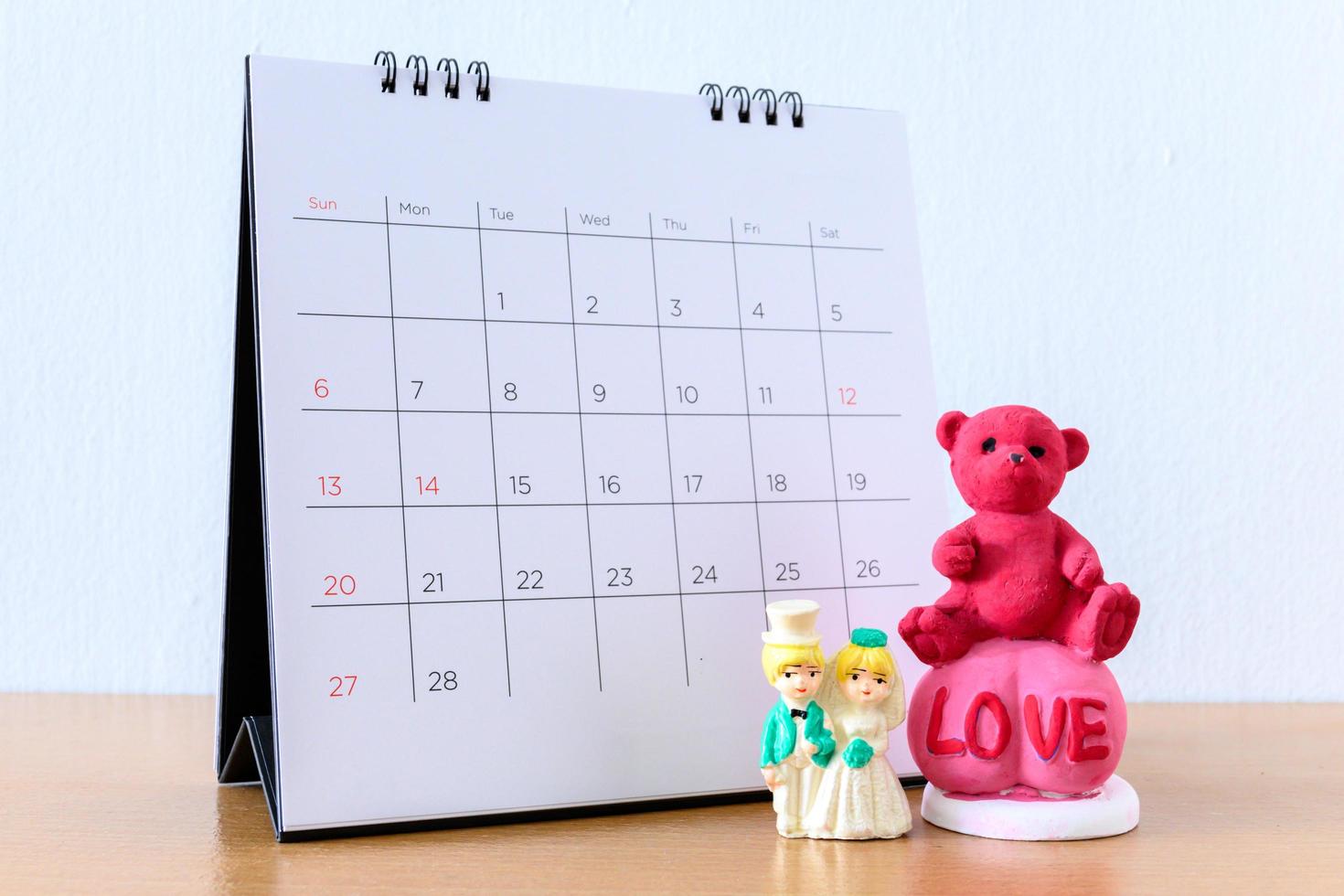 miniatyr gift par framför kalendern. koncept för bröllop alla hjärtans dag. foto
