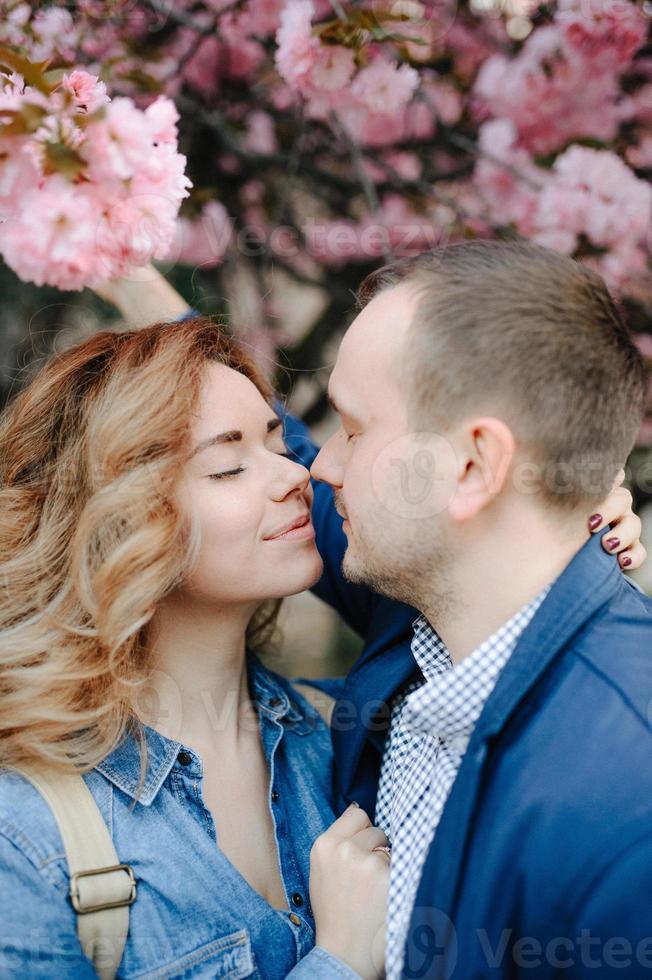 förälskat par i en blommande äppelodling liggande på filten foto