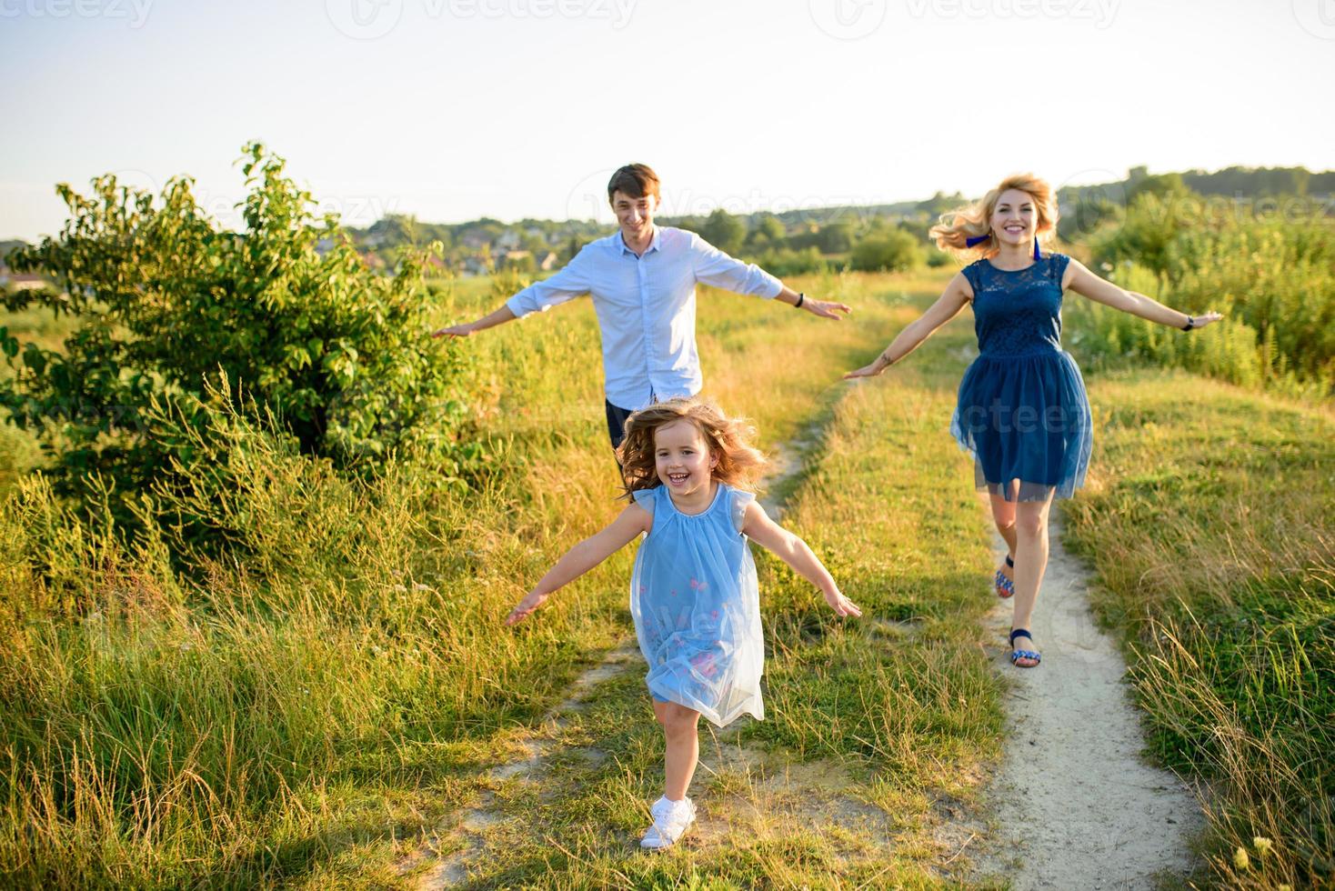 pappa mamma och dotter har roligt tillsammans i naturen. foto