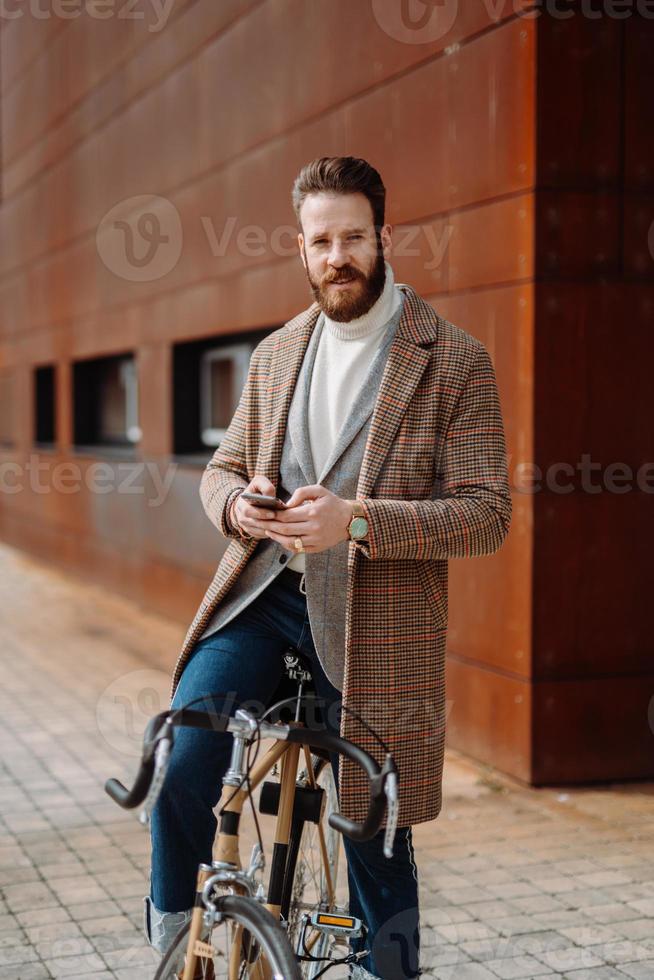 kreativ affärschef på cykeln tittar mot kameran. vertikal bild foto