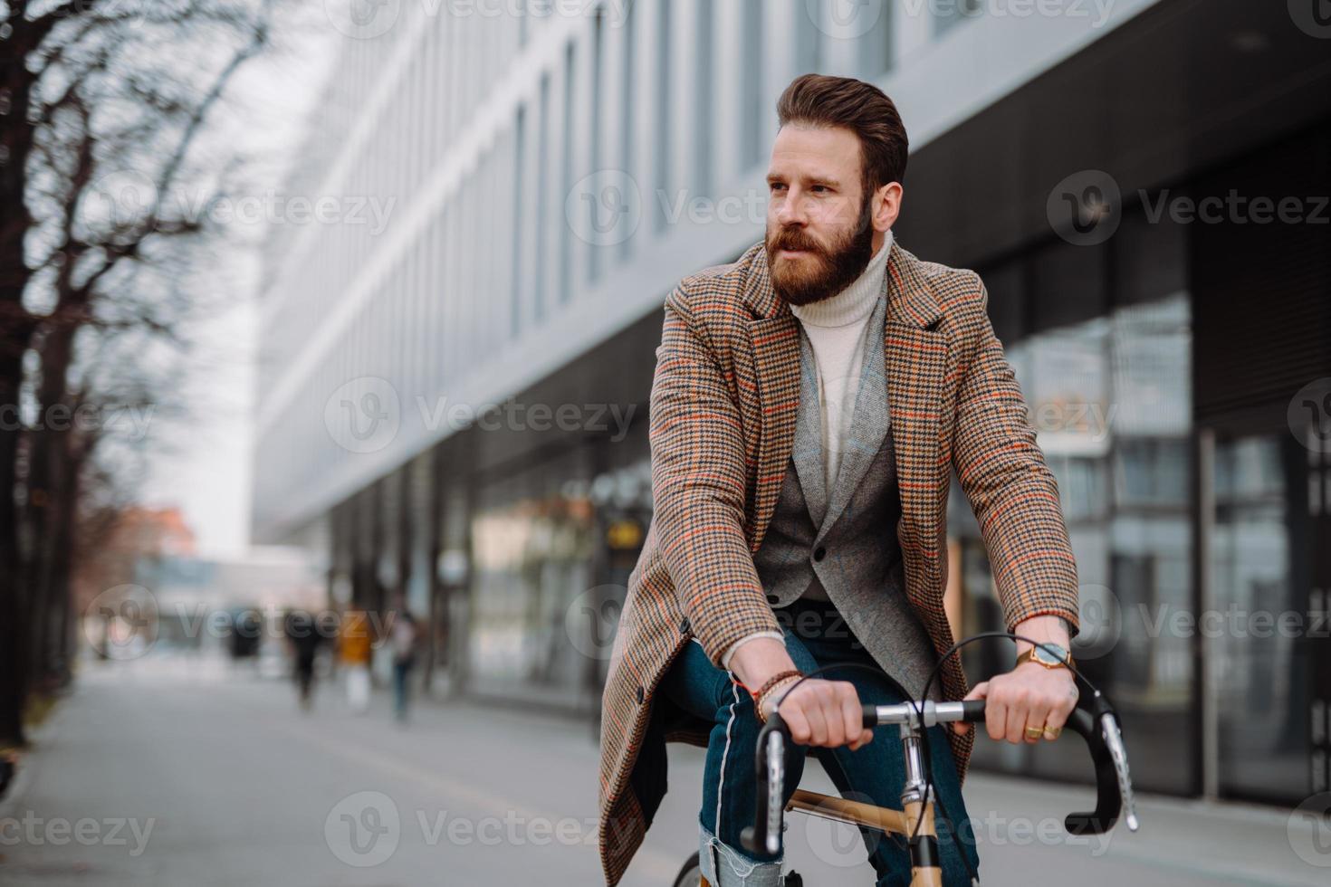 ung hipster affärsman kommer att arbeta på cykel. miljövänligt transportkoncept foto