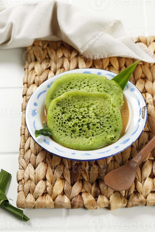 serabi pandan kuah kinca durian är traditionell indonesisk pannkaka, grön färg från pandapasta. foto