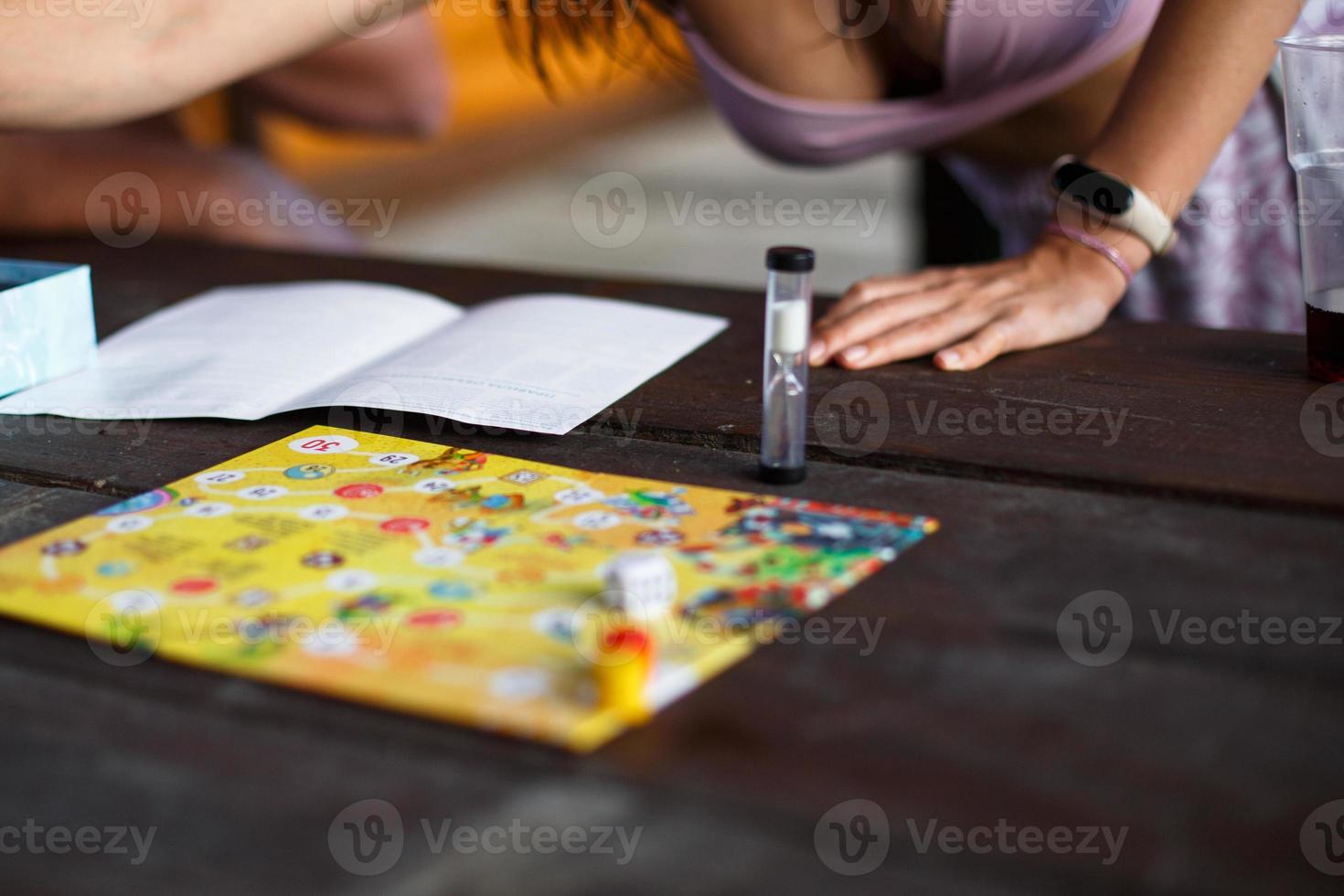 brädspelsbräda, marker, kub, timer på ett mörkt träbord och händerna i bakgrunden. begreppet lagarbete, intellektuell avkoppling, företagsevent, leka hemma med barn. kopieringsutrymme foto