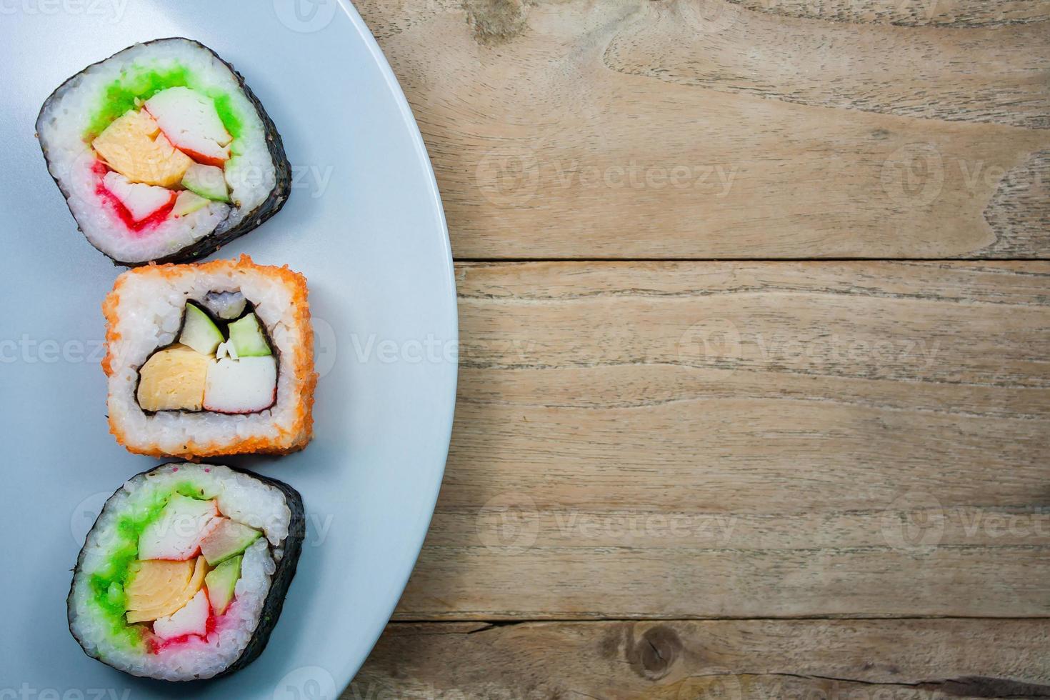 sushi maki på en tallrik över träbord foto