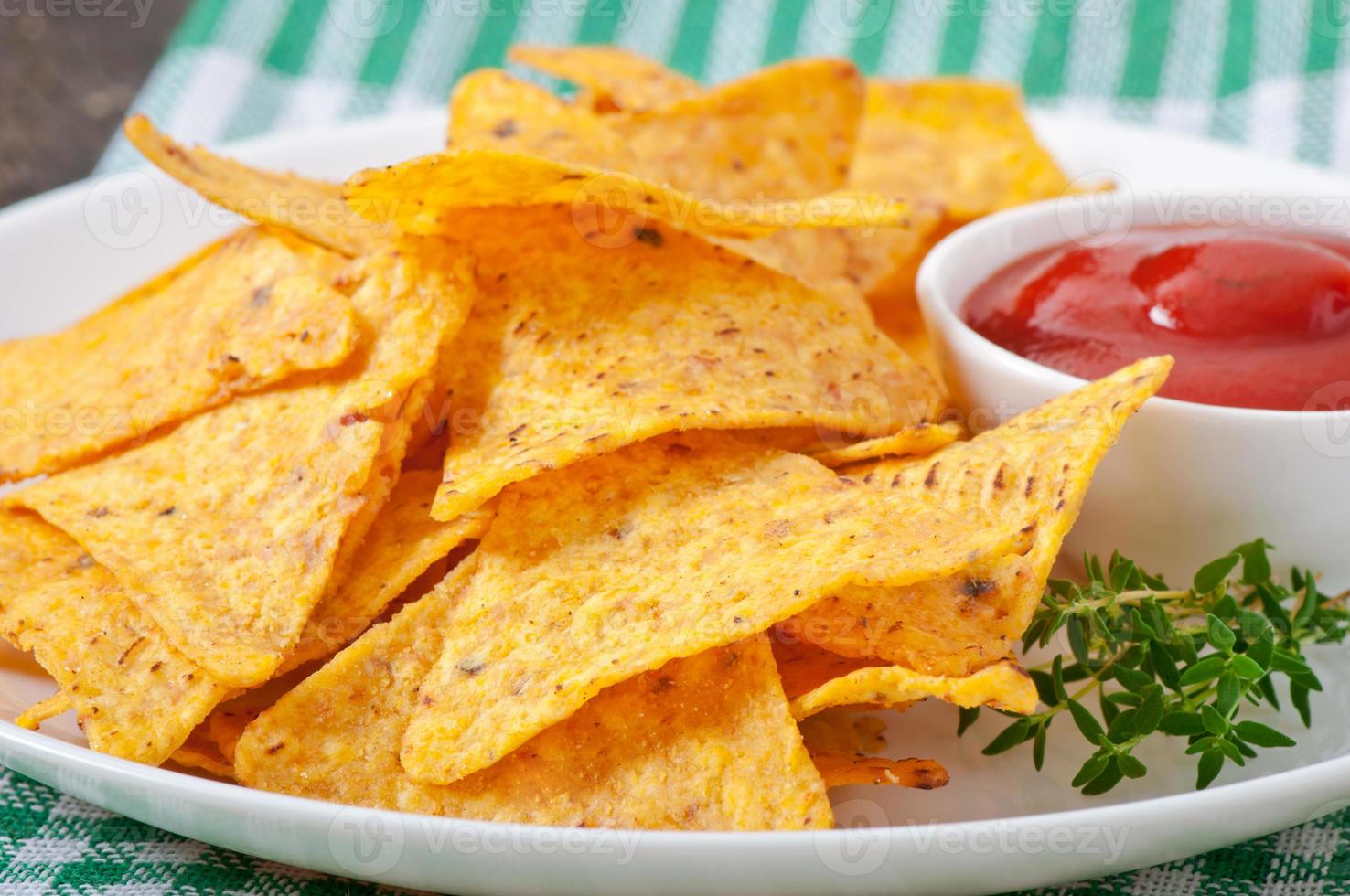 nachos och tomatdipp dekorerad med timjanblad foto