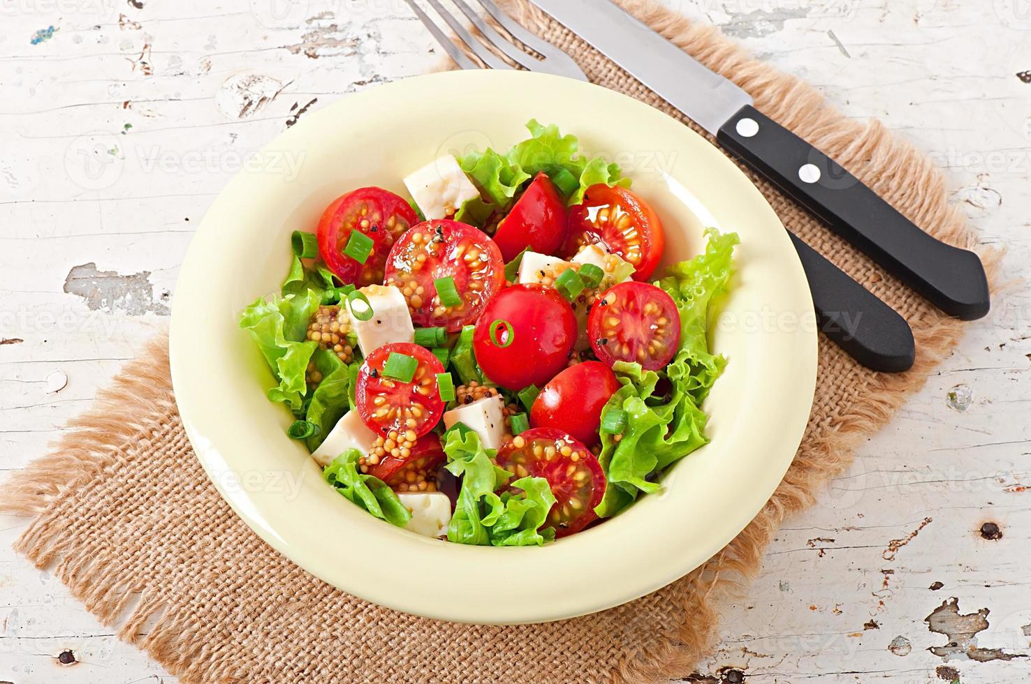 tomatsallad med sallad, ost och senap och vitlökdressing foto