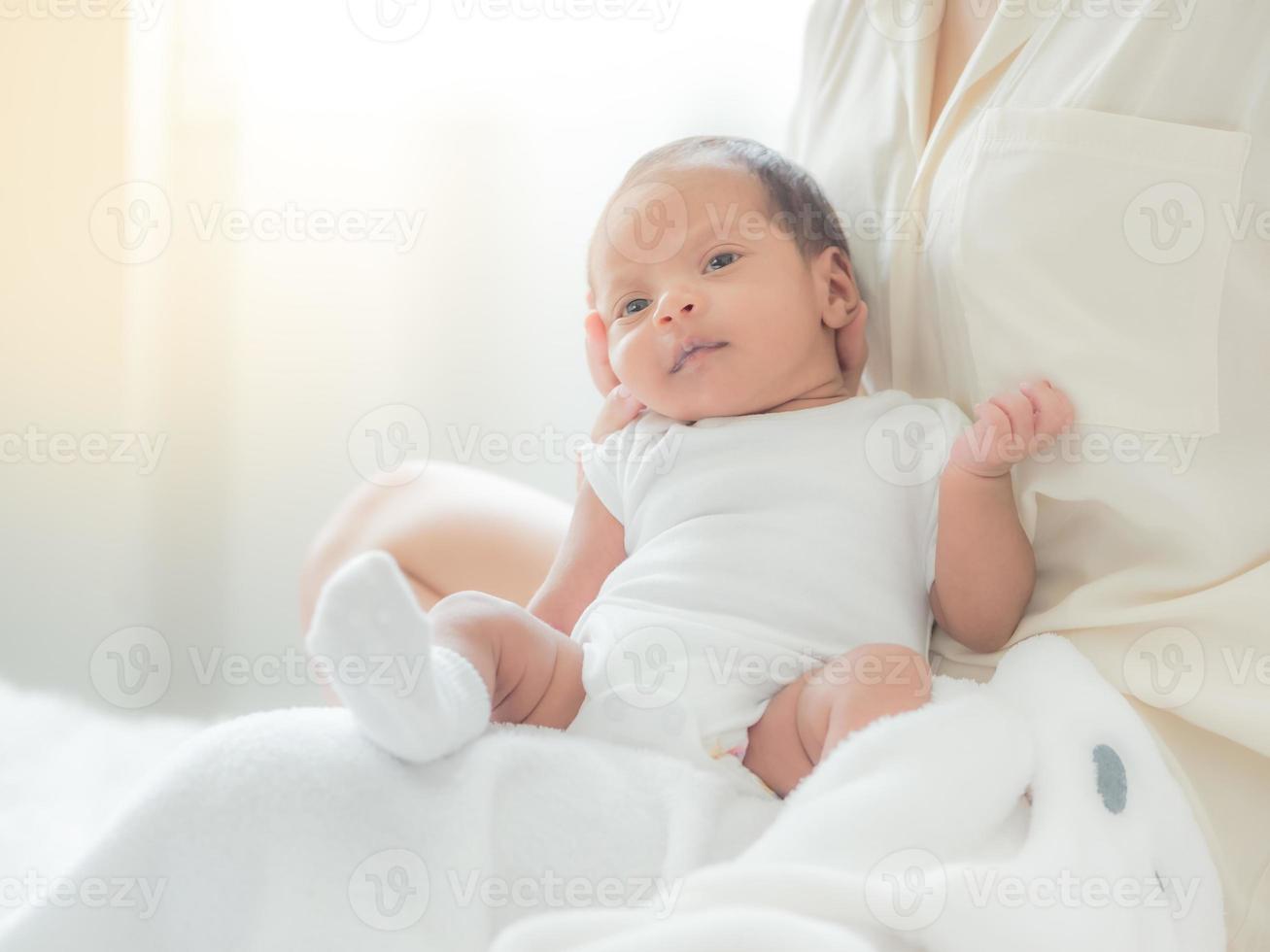 en vacker asiatisk kvinna sätter sitt nyfödda barn på sin kropp glatt och med kärlek foto