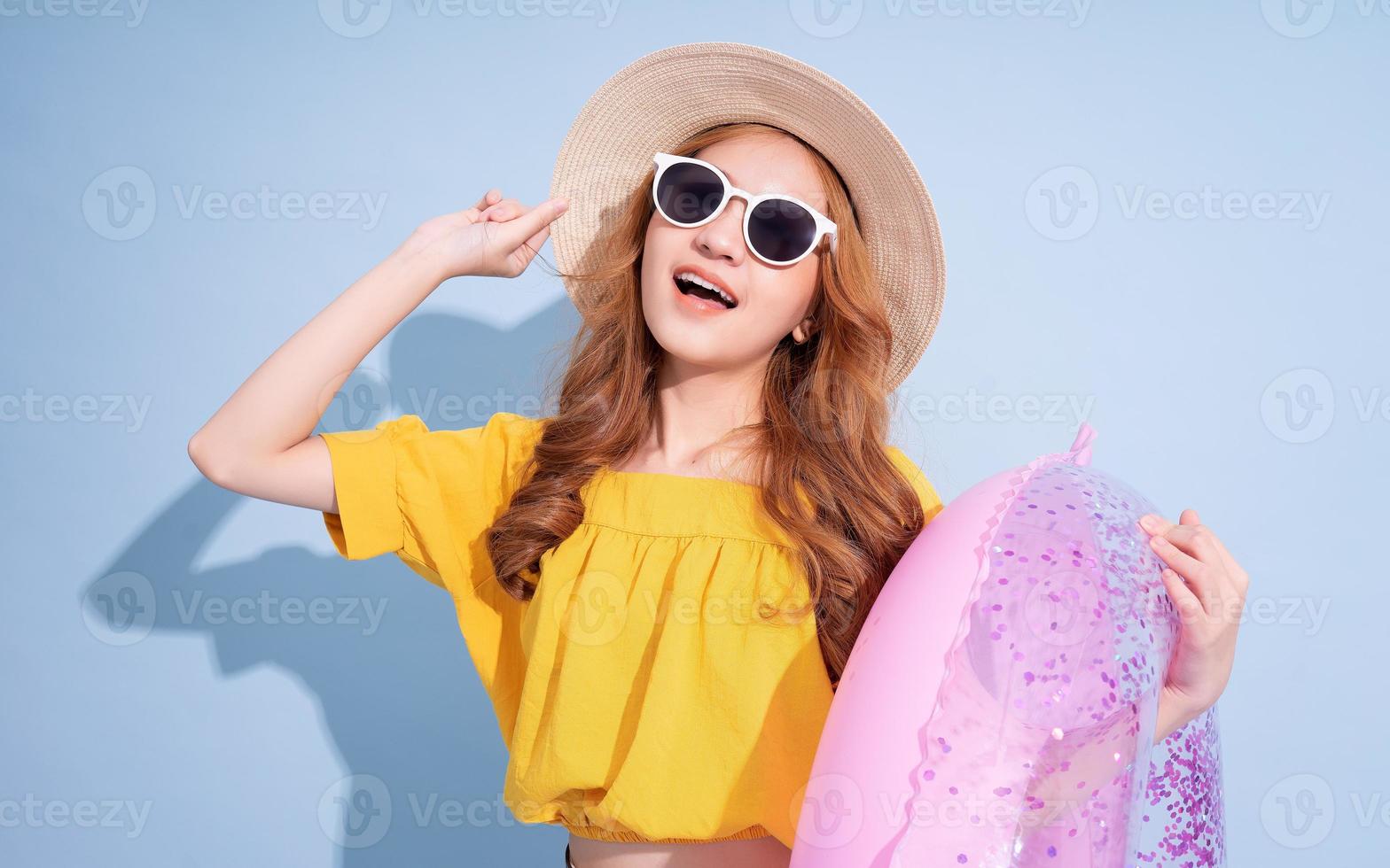 porträtt av ung asiatisk flicka på blå bakgrund, sommarsemester koncept foto
